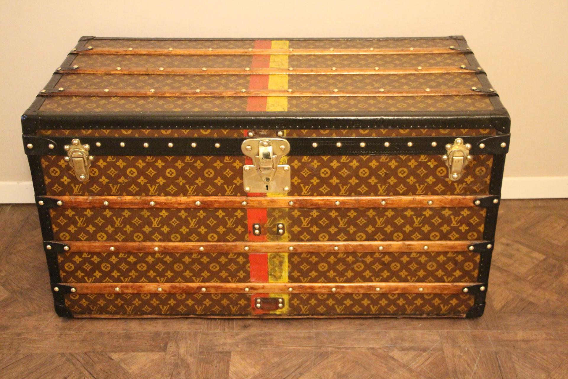 This Louis Vuitton trunk features stenciled canvas, deep black lozenge trim, black steel side handles, solid brass Louis Vuitton stamped brass lock and clasps as well as Louis Vuitton stamped brass studs. Yellow and red customized painted stripes.