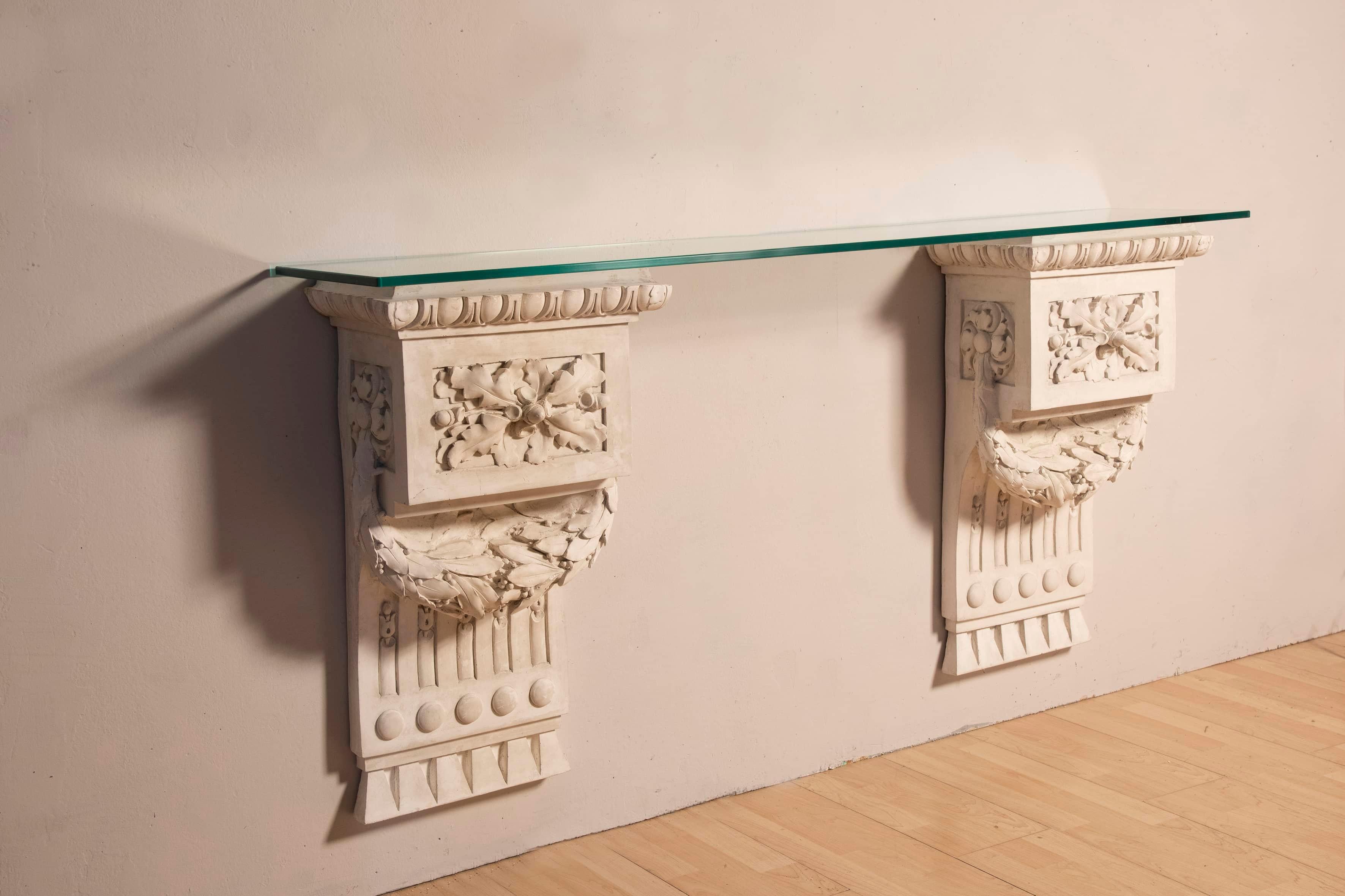 Two plaster friezes from the early 1900s in Louis XVI style offered here as supporting structures for a console table with a glass top ( of recent production ) .  Measurement of the console table thus composed W160 D 31 H 80 CM . They also lend