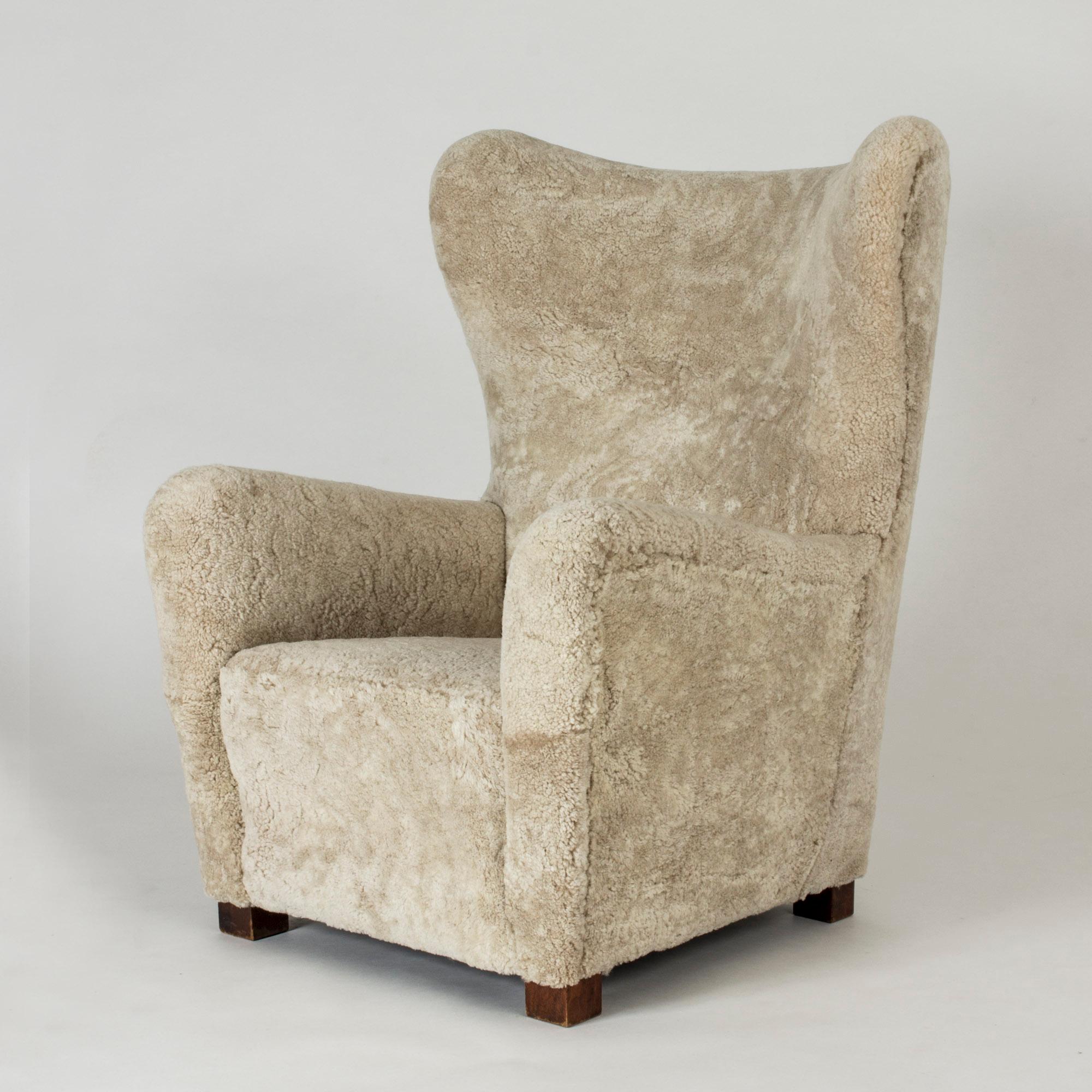 Elegant 1930s lounge chair from Fritz Hansen, with clean, stately lines. Upholstered with sheepskin that softens the silhouette.