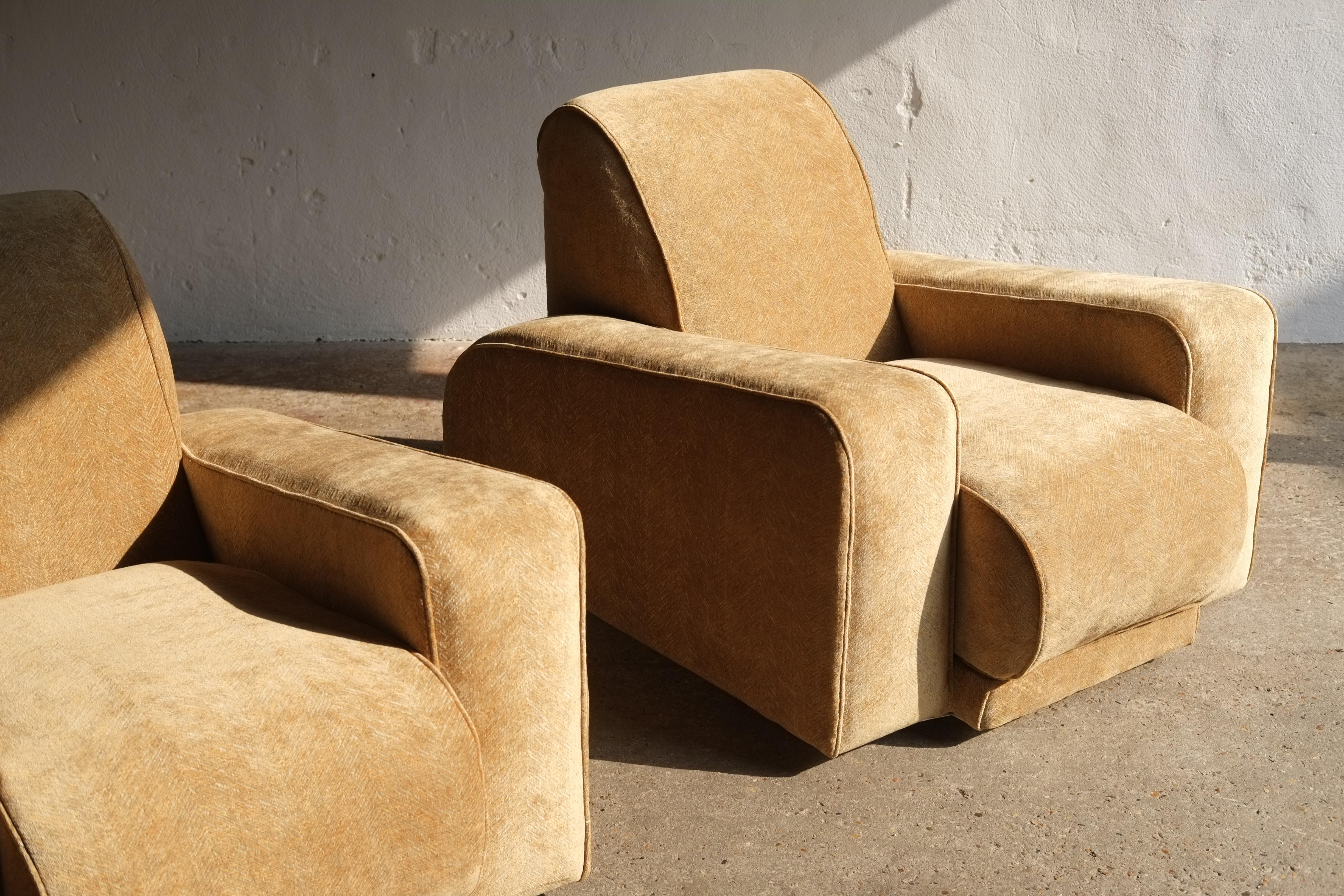 An incredible pair of 1930's Art Deco lounge chairs attributed to the Bowman brothers, featuring slanted armrests and a grand scale.

The chairs have been newly reupholstered in a high quality golden Marvick textile. 

Price is for the pair. 