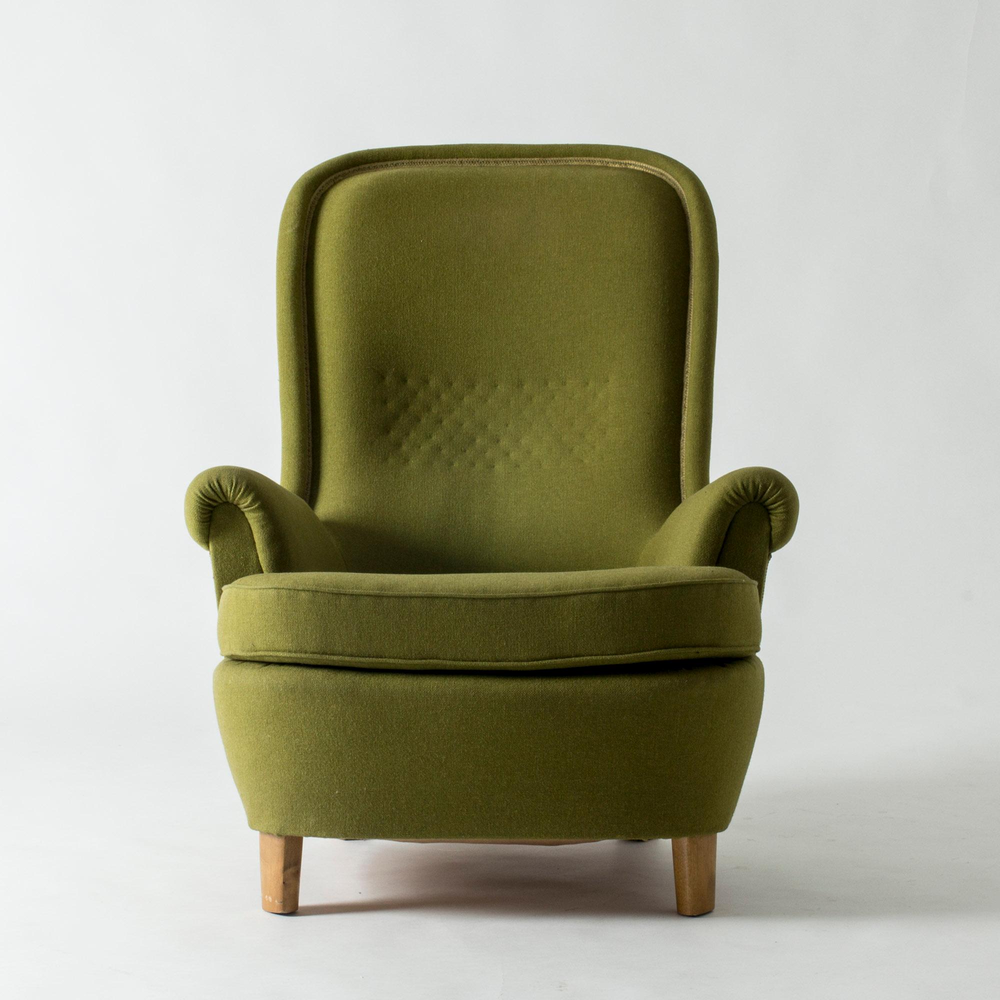Imposing lounge chair by Carl-Axel Acking, designed in 1937 for the World Exhibition in Paris. Beautiful, oversized arched back and a laid back silhouette. Older upholstery.