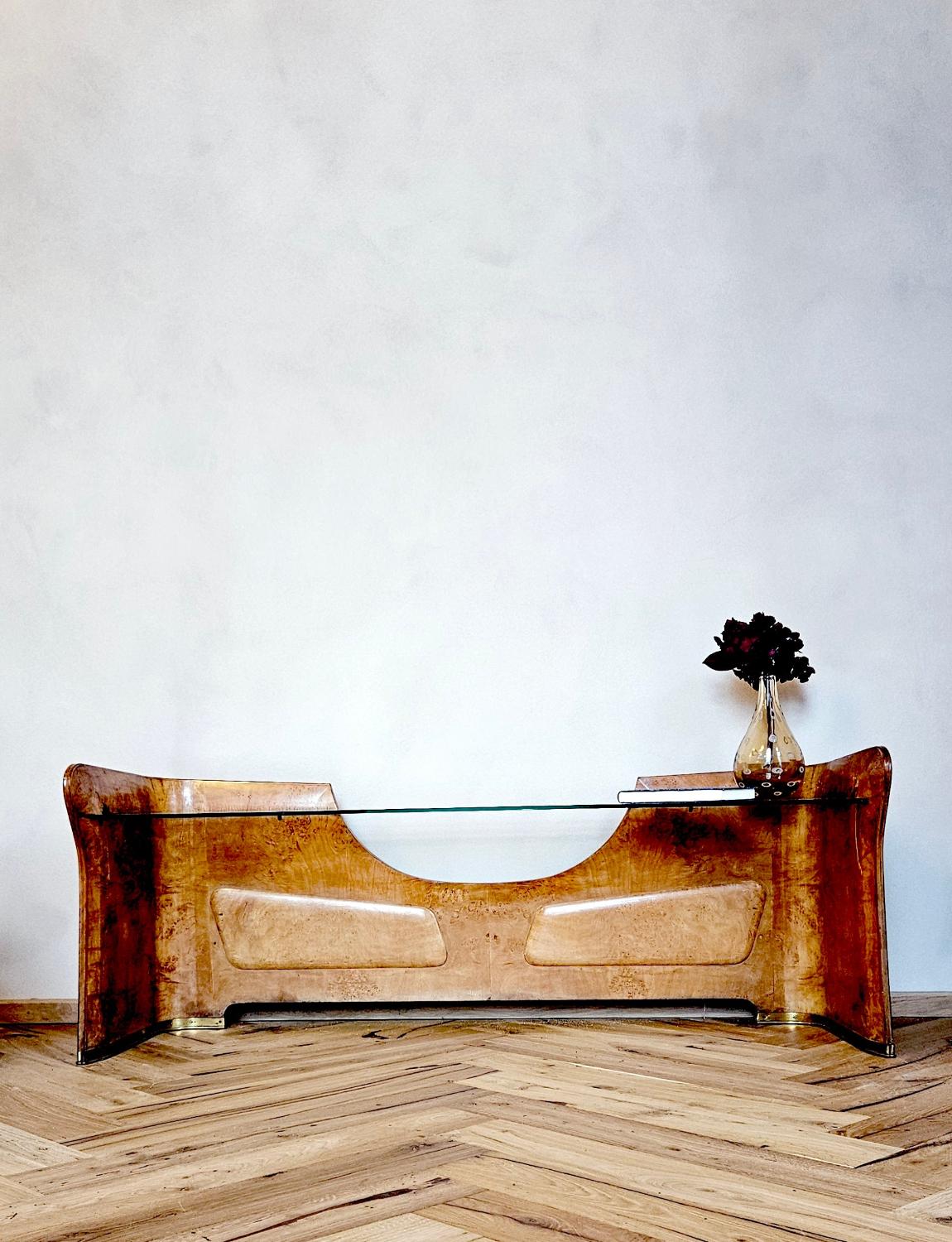 A beautiful Italian solid walnut low console table with glass top. Perfect against a wall in a living room or bedroom. The walnut frame has carved wood decorative internal panels and the base has solid brass free.  A beautiful piece in good