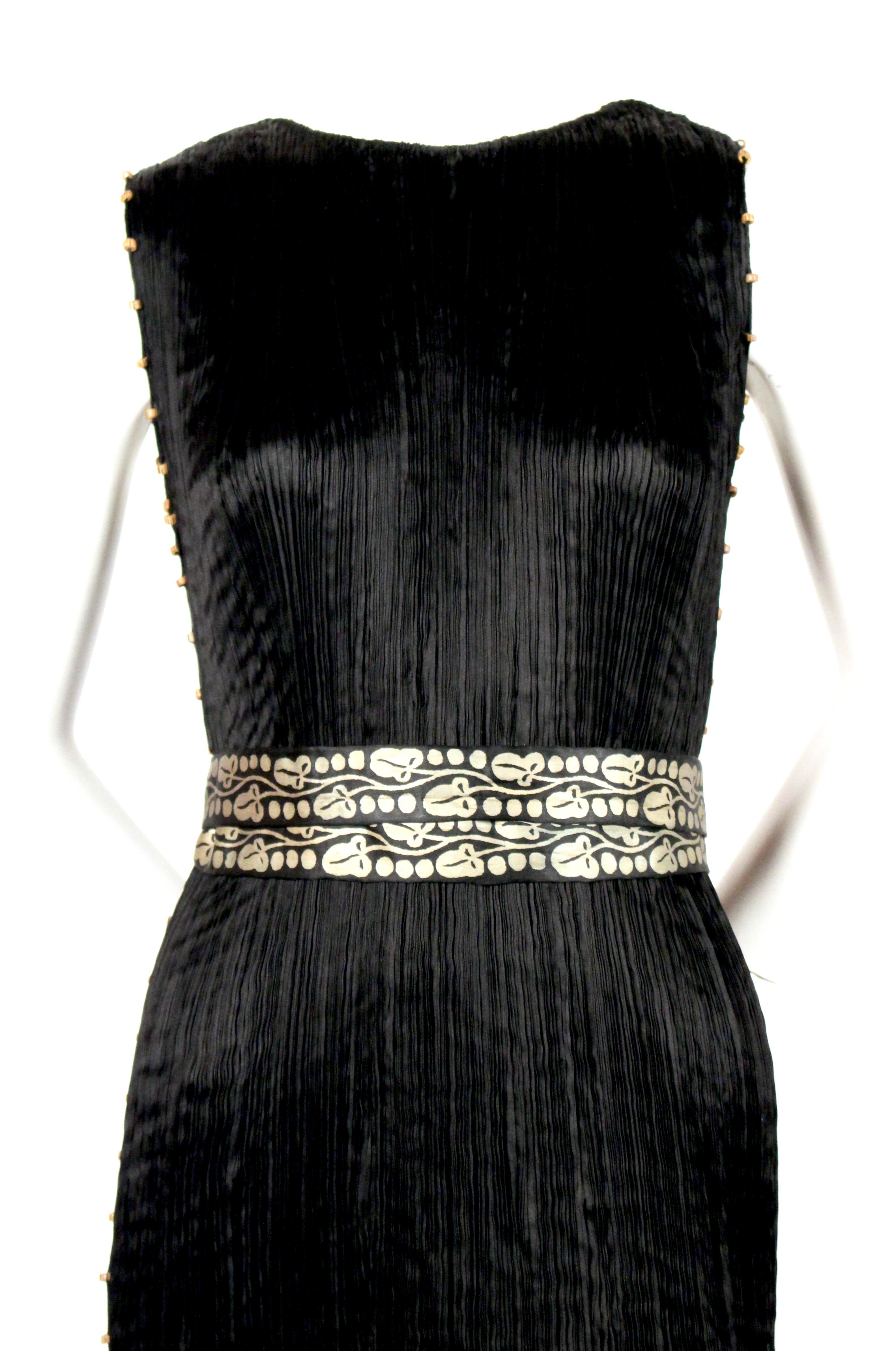 Jet-black, micro-pleated, silk 'Delphos' gown with Venetian striped glass beads and stamped gold silk belt from Mariano Fortuny dating to the 1930's. Fits a variety of sizes due to the pleated construction however this has been photographed on a