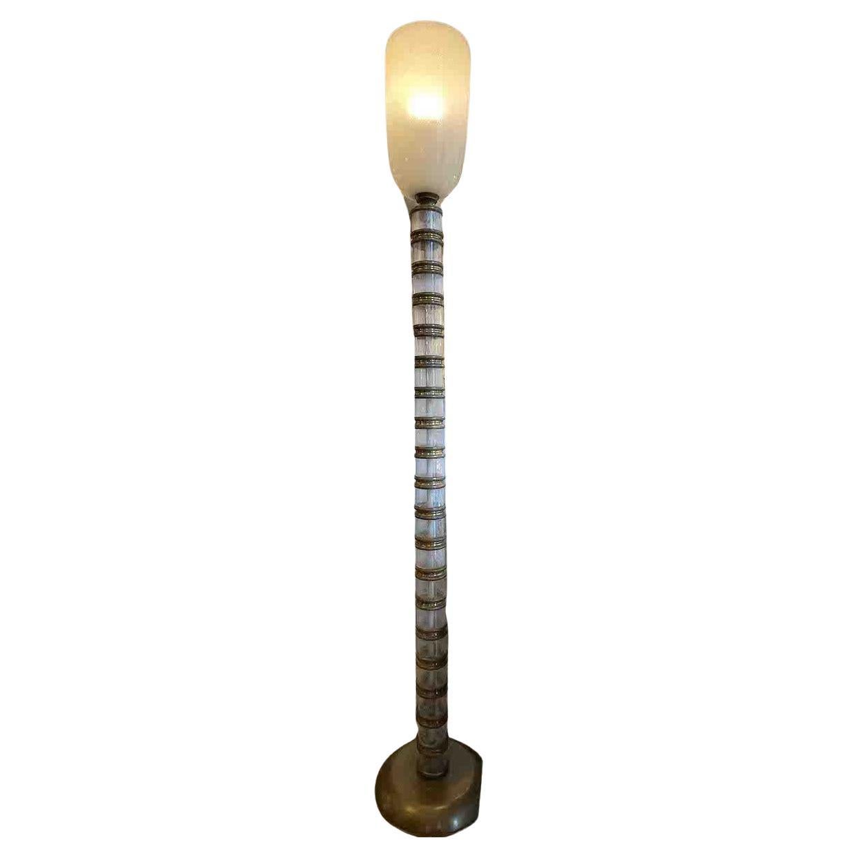 Venini 1930s pulegoso glass and brass floor lamp.
The base of the lamp was produced in patinated brass and was made by Martinuzzi for Venini.

The pulegoso glass is filled with bubbles obtained by introducing a substance into the molten mass that