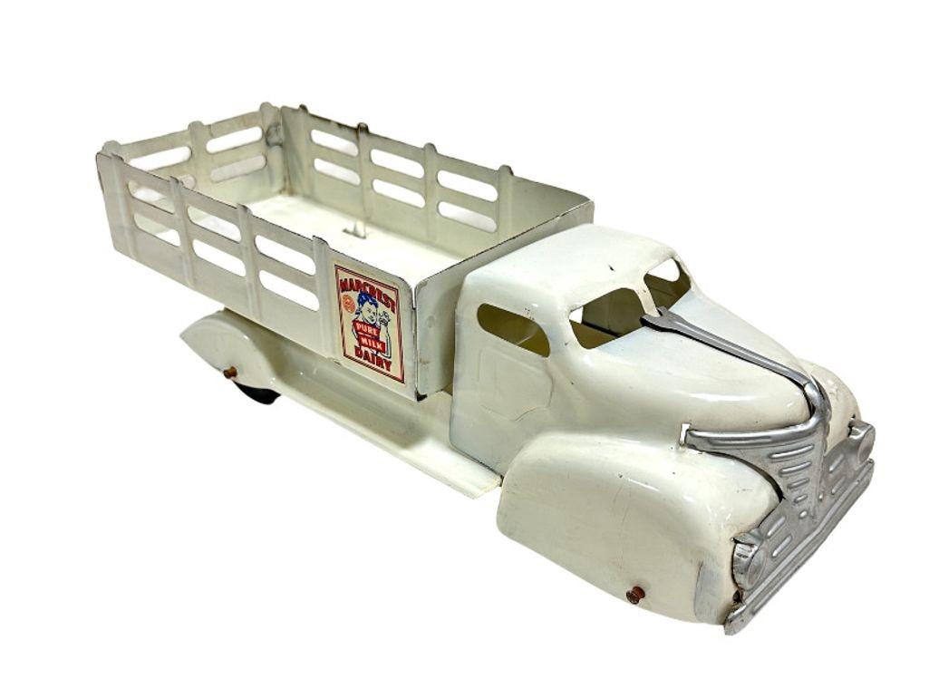 We have A white Marx Marcrest Pure Milk Dairy Truck modeled truck produced by Marx Toys, a prominent American toy company known for manufacturing a wide range of toys in the 1920s. The Marcrest Pure Milk Dairy Truck was designed to resemble a