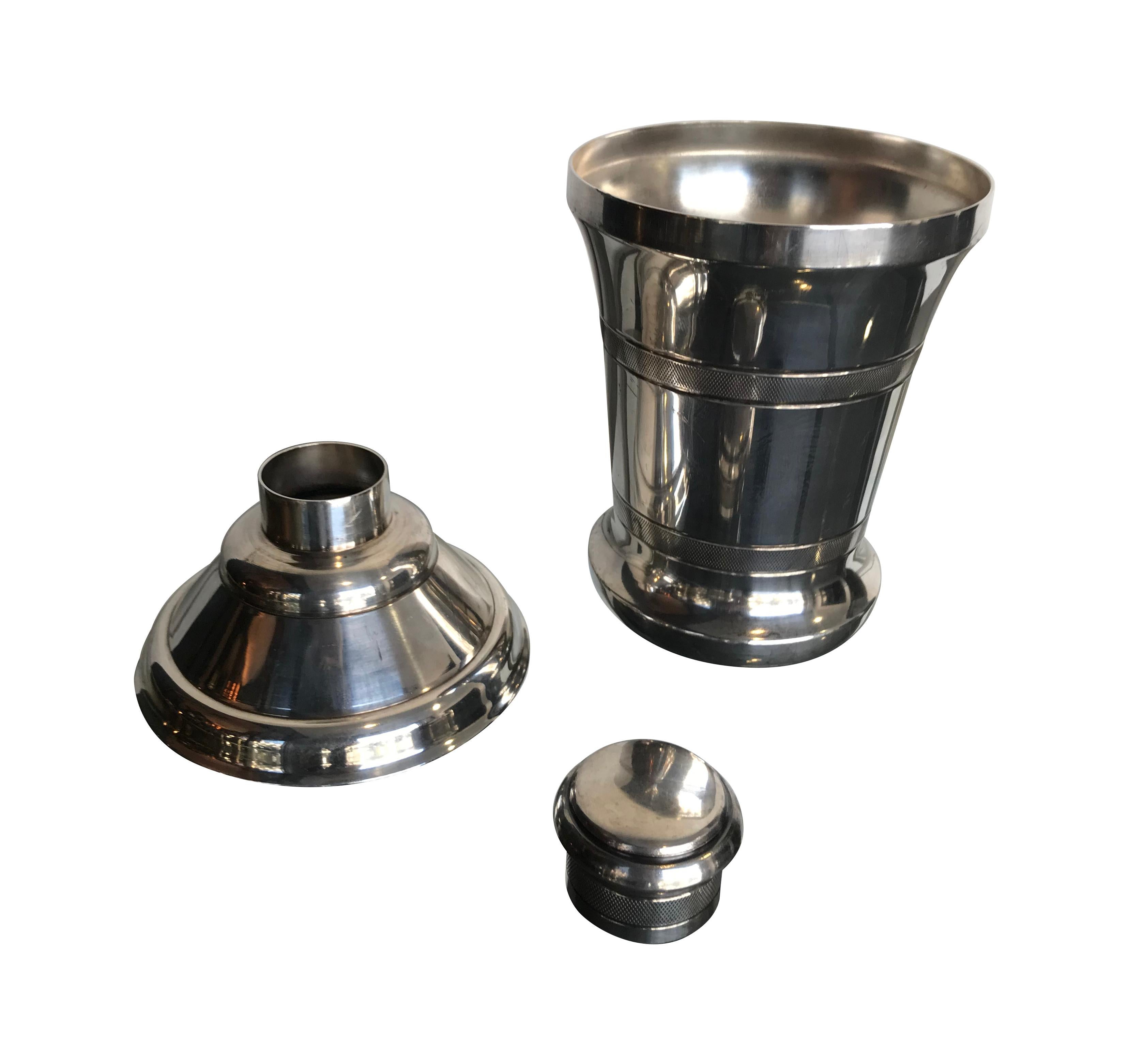 A 1930s matching silver plated champagne cooler and cocktail shaker, each with curved base and etched details. Cocktail shaker measures 21 cm high / 8 1/4 