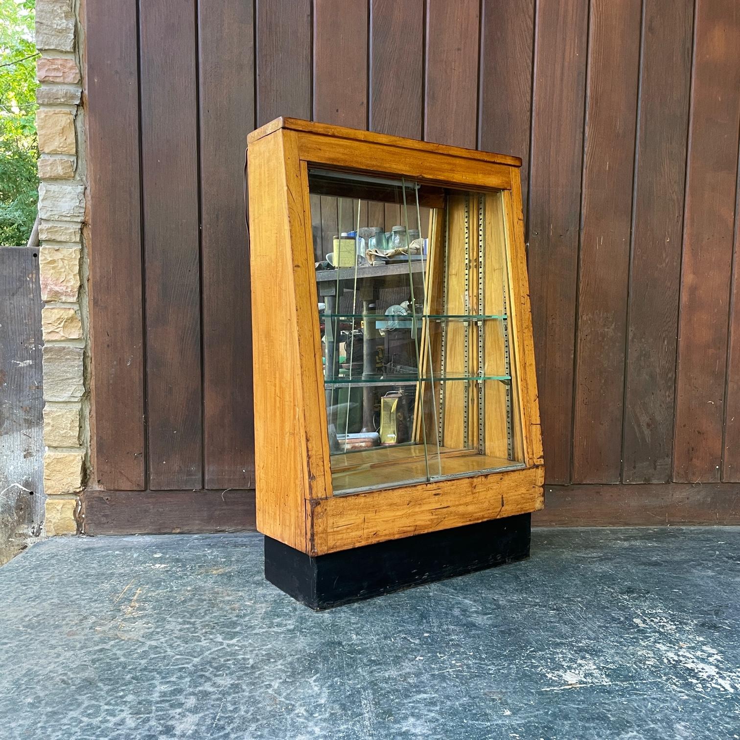 Heavily Worn and Patinated, Scarred and Marred. 

2 Sliding Glass Door Slant Front Display Floor Case. Lighting was added later and is working.  More shelves could be added, but it comes with 2.