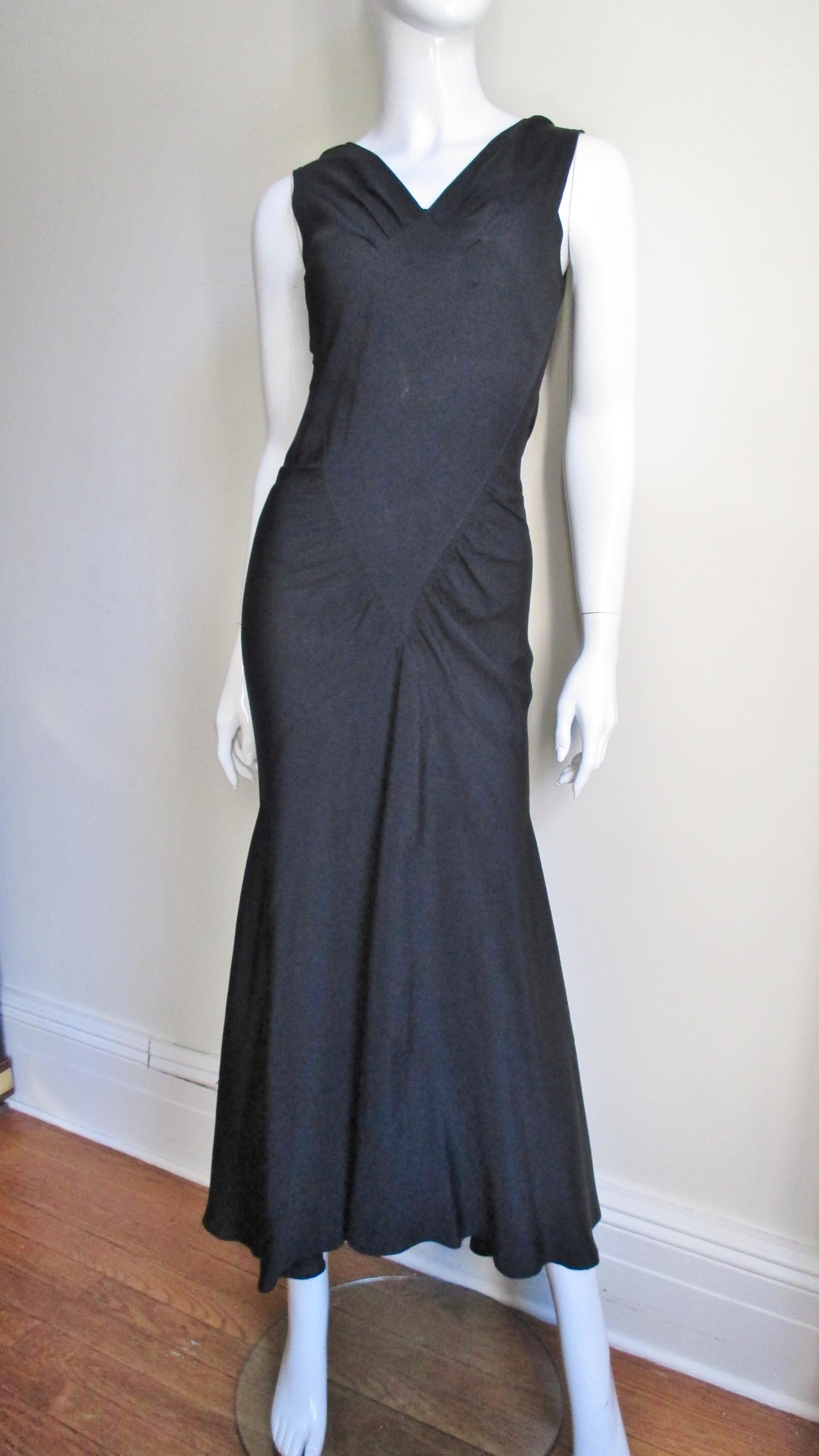 A black silk 1930's gown with incredible seaming and lines.  The front has lightly shirred panels sewn onto a diamond shaped front panel.  It is sleeveless with a V neck front and scoop back.  Fitted through the torso via the shirring and triangular