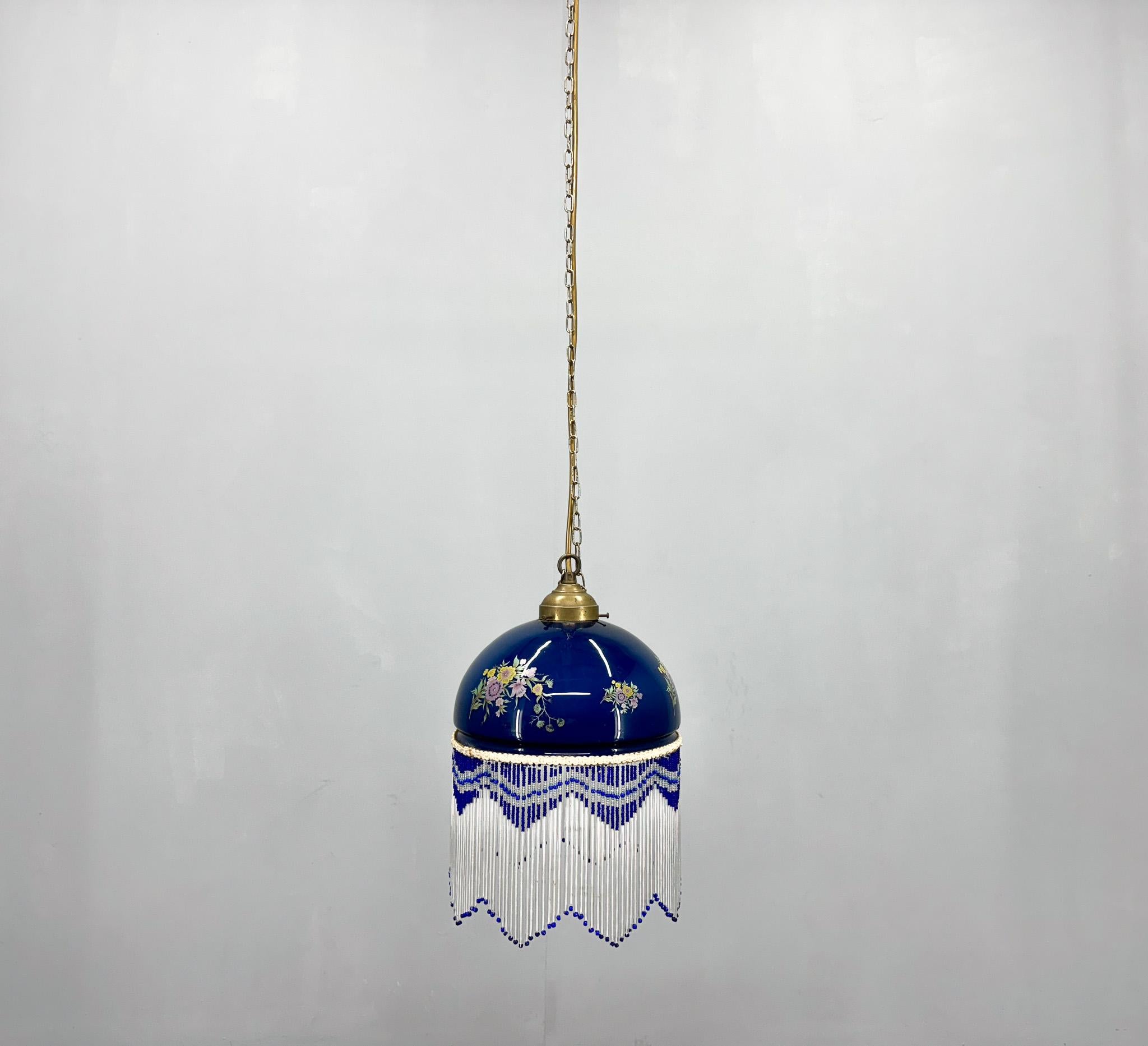 Antique long pendant lamp in metal and glass with brass finish and glass fringe. In dark blue with a delicate, colourful flower pattern. Bulb: 1 x E14. US wiring compatible.