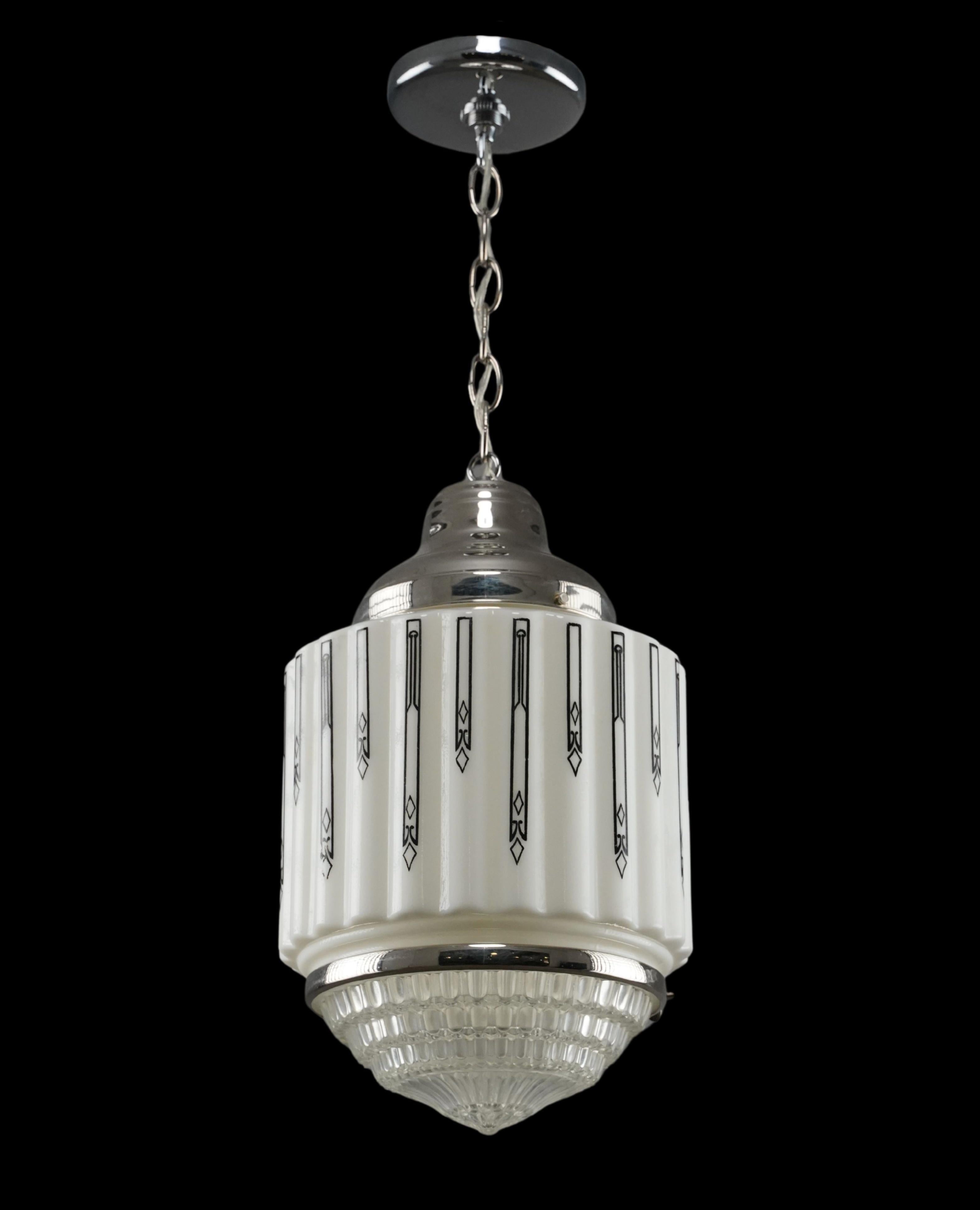 Lampada a sospensione in stile Art Deco degli anni '30 con globo in vetro lattimo bianco e nero, fondo in vetro fresnel trasparente e catena e montatore in acciaio con finitura cromata. Richiede una lampadina standard di tipo Edison a base media.