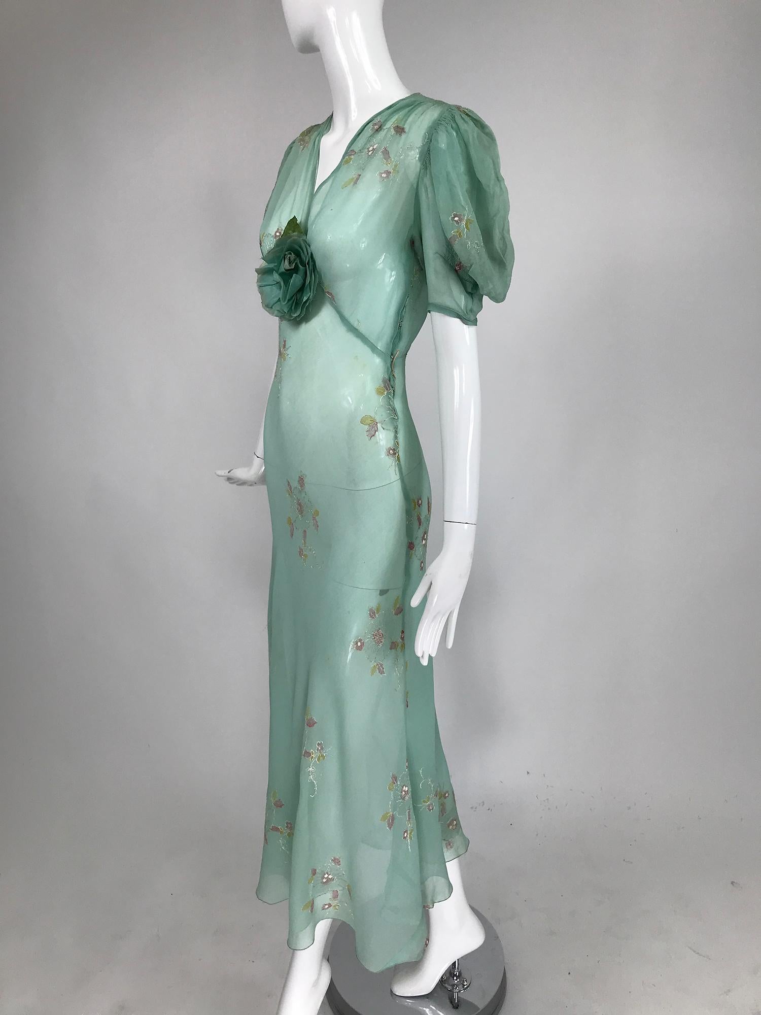      1930s mint green, hand embroidered, bias cut sheer silk chiffon maxi dress. This amazing vintage 30s dress is so evocative of the period. V neck dress has elbow length puff sleeves, the dress has a matching green rose corsage at the bust