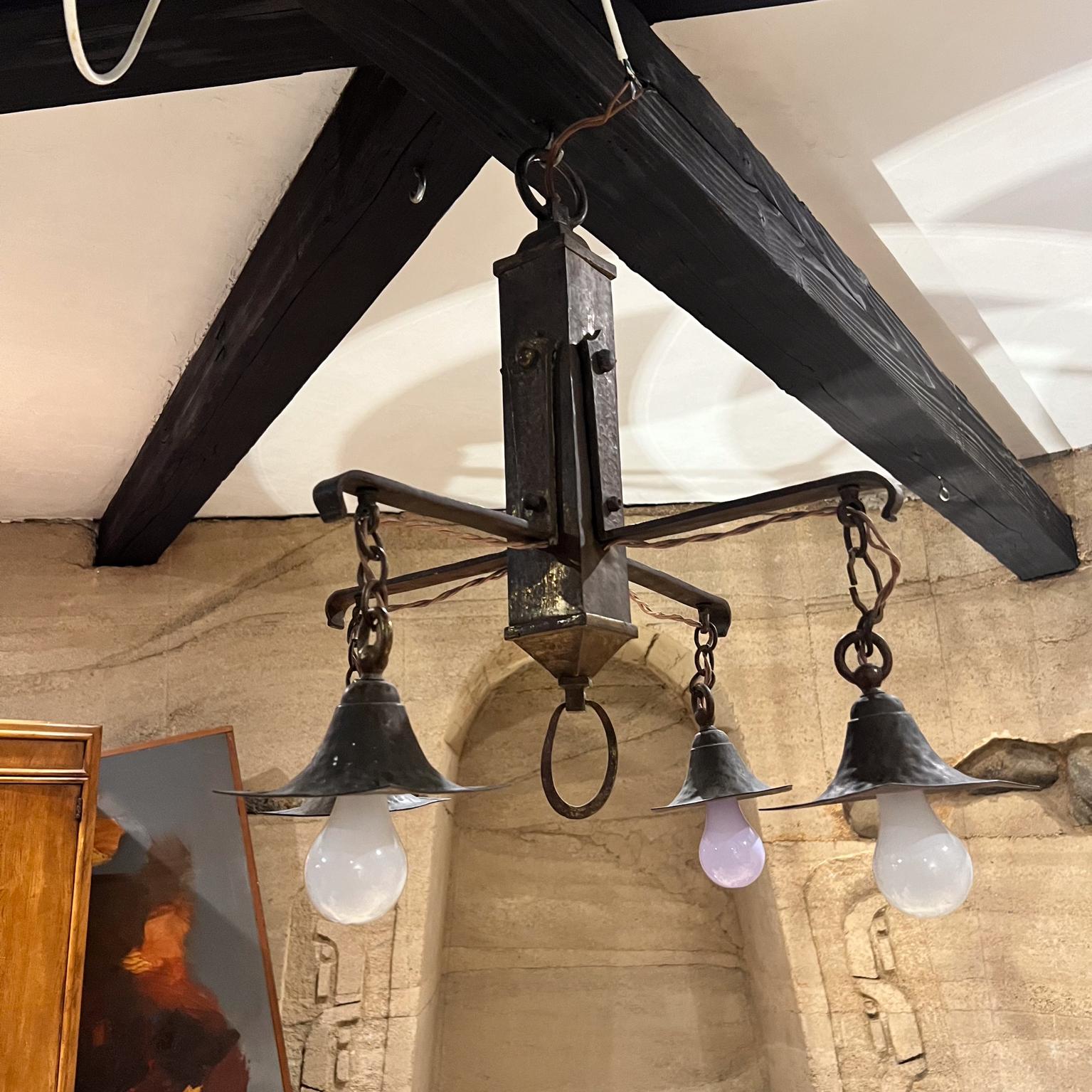 
Antique Mission Chandelier Solid Brass.
Hand-hammered texture.
No markings 
Chandelier hangs from one brass ring.
Edison bulbs (40 watts) are exposed, giving a soft light.
23 H  x 23 D x 23 W
Exposed bulbs not included.
Original vintage patina.