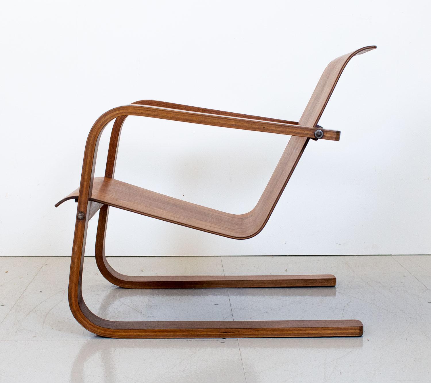 A rare 1930s modernist cantilever armchair very much in the style of Alvar Aalto and Marcel Breuer. This has been made using a walnut veneered plywood to create a strong but classic design with a hinged seat and sweeping curved armrests. The natural