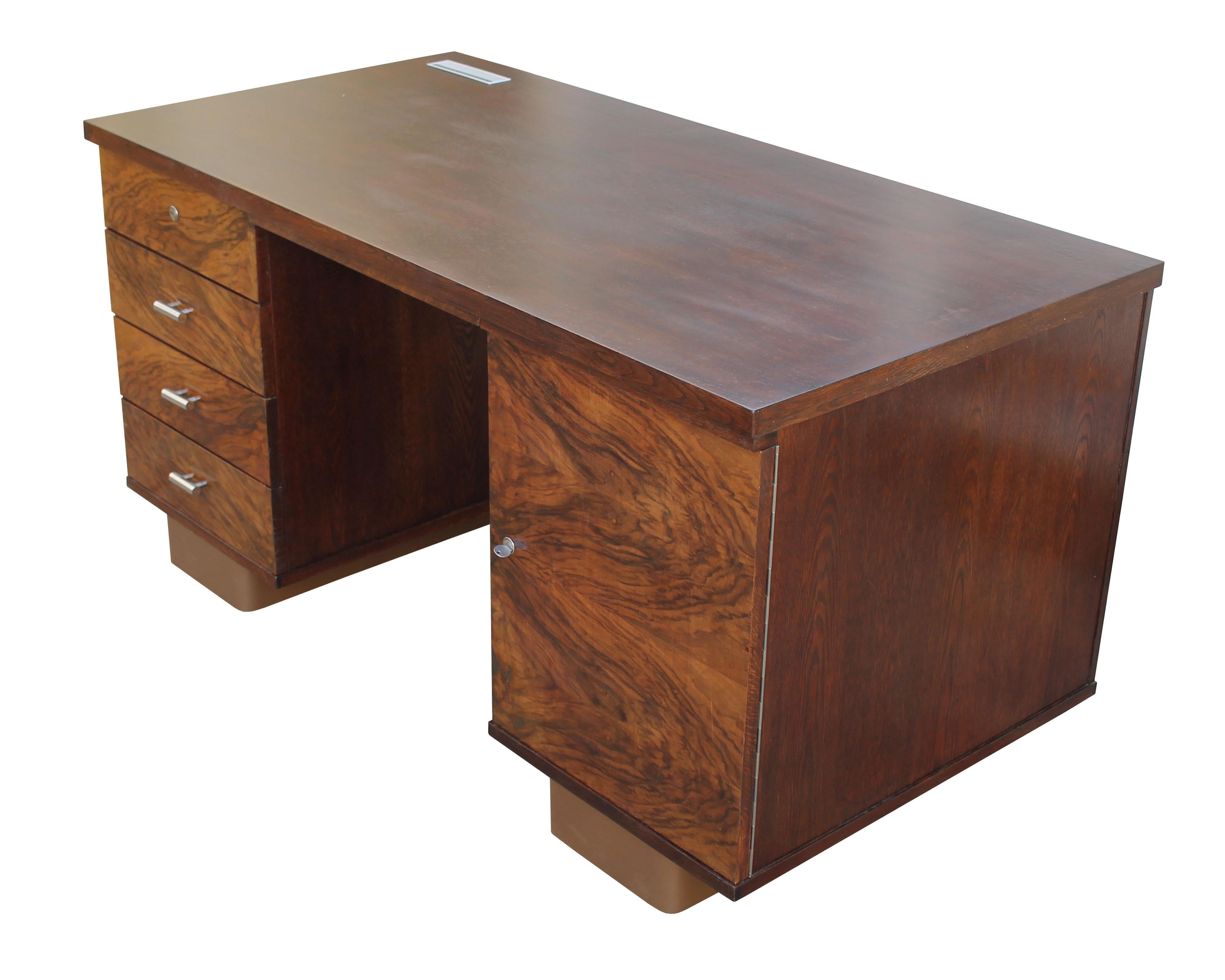 An original Modernist desk from the 1930s. This piece has a dignified design with stylish proportions and details together with a dazzling Walnut pattern and dark brown Oak.

This writing / office desk has a rectangle table top made of Oak. The