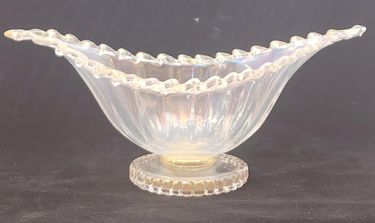 1930's hand blown glass bowl by Murano maestro Ecole Barovier for Artistica Barovier. The bowl shape looks like it's inspired by a cactus shape and is made from iridato glass and trimmed with applied pasta glass with gold inclusions on a pedestal