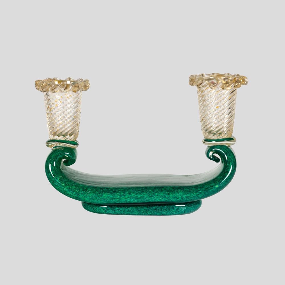 1930s Murano glass Barovier and Toso candle holder.

This exquisite two candles holder was hand blown in Italy in the 1930s by the famous Barovier and Toso glassworks. Clear glass decorated with swirls of gold and moss green base, giving it a