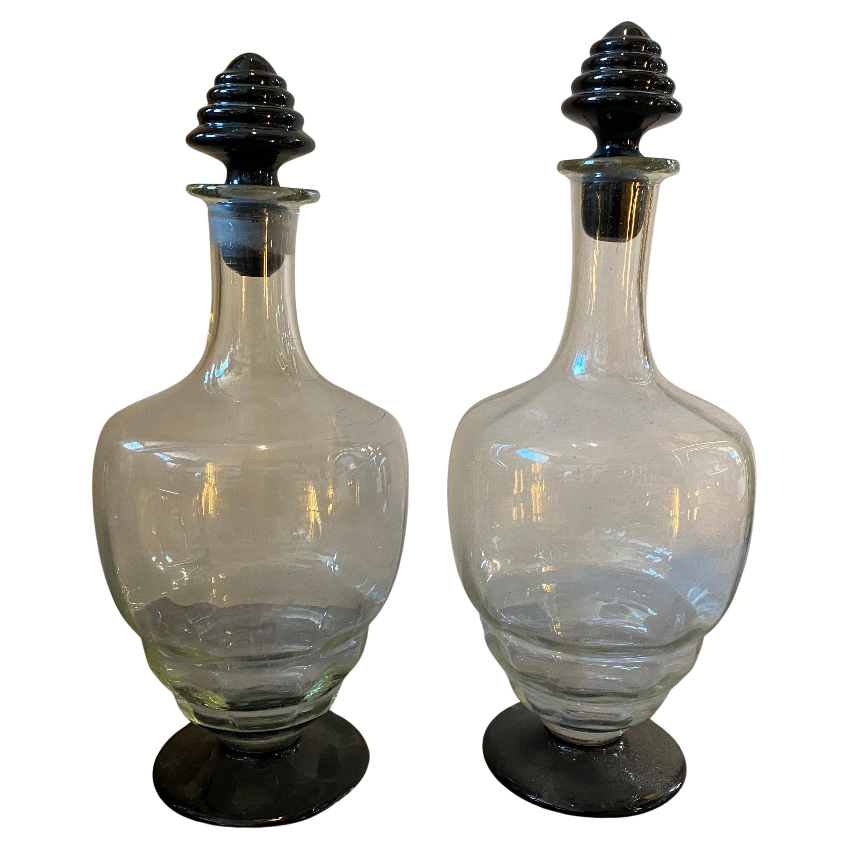 Two clear and black murano glass liquor bottles manufactured in Italy in the Thirties in the style of Napoleone Martinuzzi. One bottle it's 31 cm in height, the other one is 29 cm in height. They are in perfect condition as you can see in the