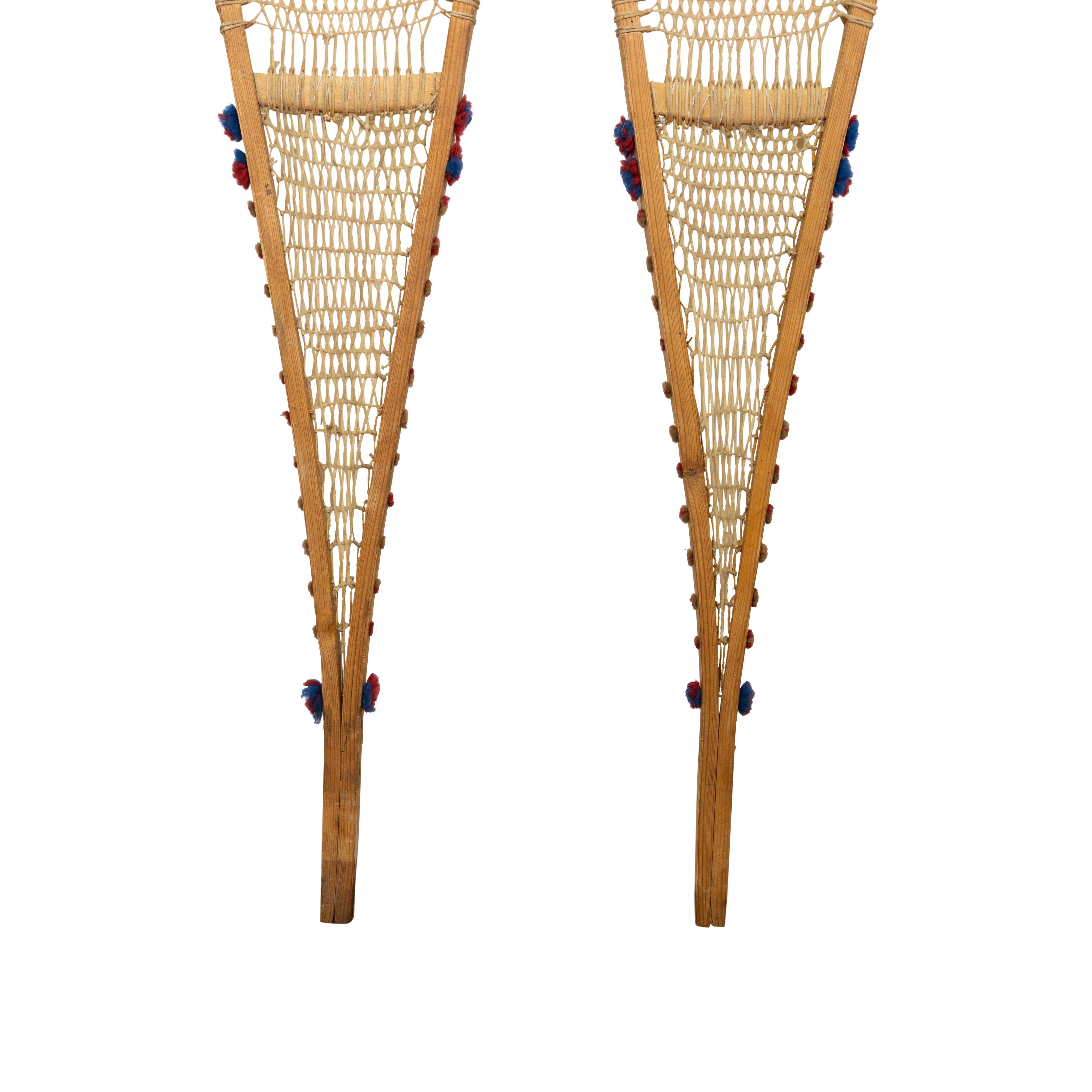 Von den Ojibwe-Indianern hergestellte und verwendete Schneeschuhe mit roten und blauen Wolltuffs. Gebraucht, aber leicht. 58