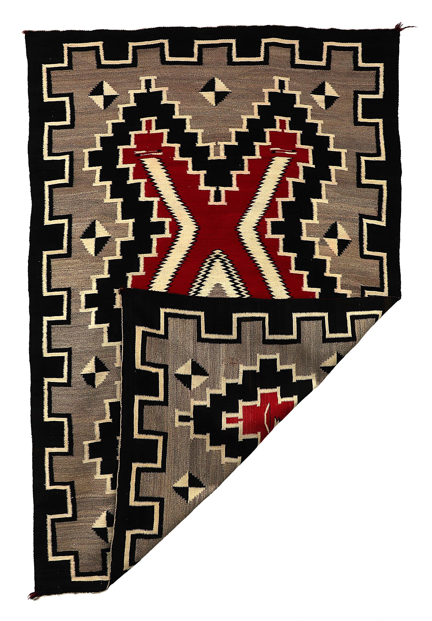 Esta alfombra navajo vintage de los años 30 es un impresionante ejemplo de tejido pictórico Ganado, con un motivo de arco y flecha. Tejida con lana autóctona hilada a mano, la alfombra presenta colores naturales de vellón, como el marfil (blanco),