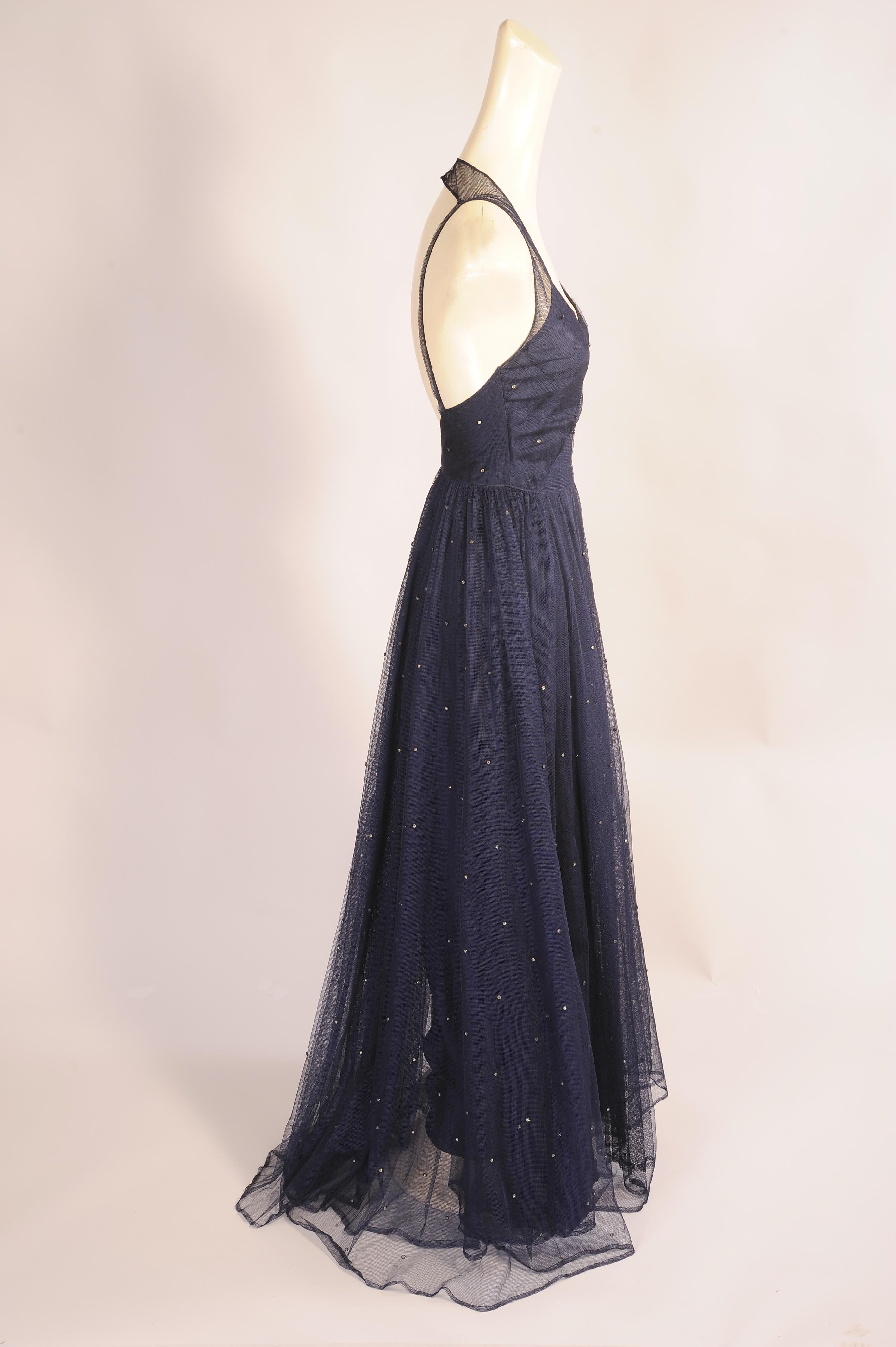 Like twinkling stars in the night sky, rhinestones glisten on this beautiful 1930's cotton net dress. It has a halter style neckline with narrow straps at the back. The fitted bodice has a left side metal zipper and the skirt is two layers of tulle.