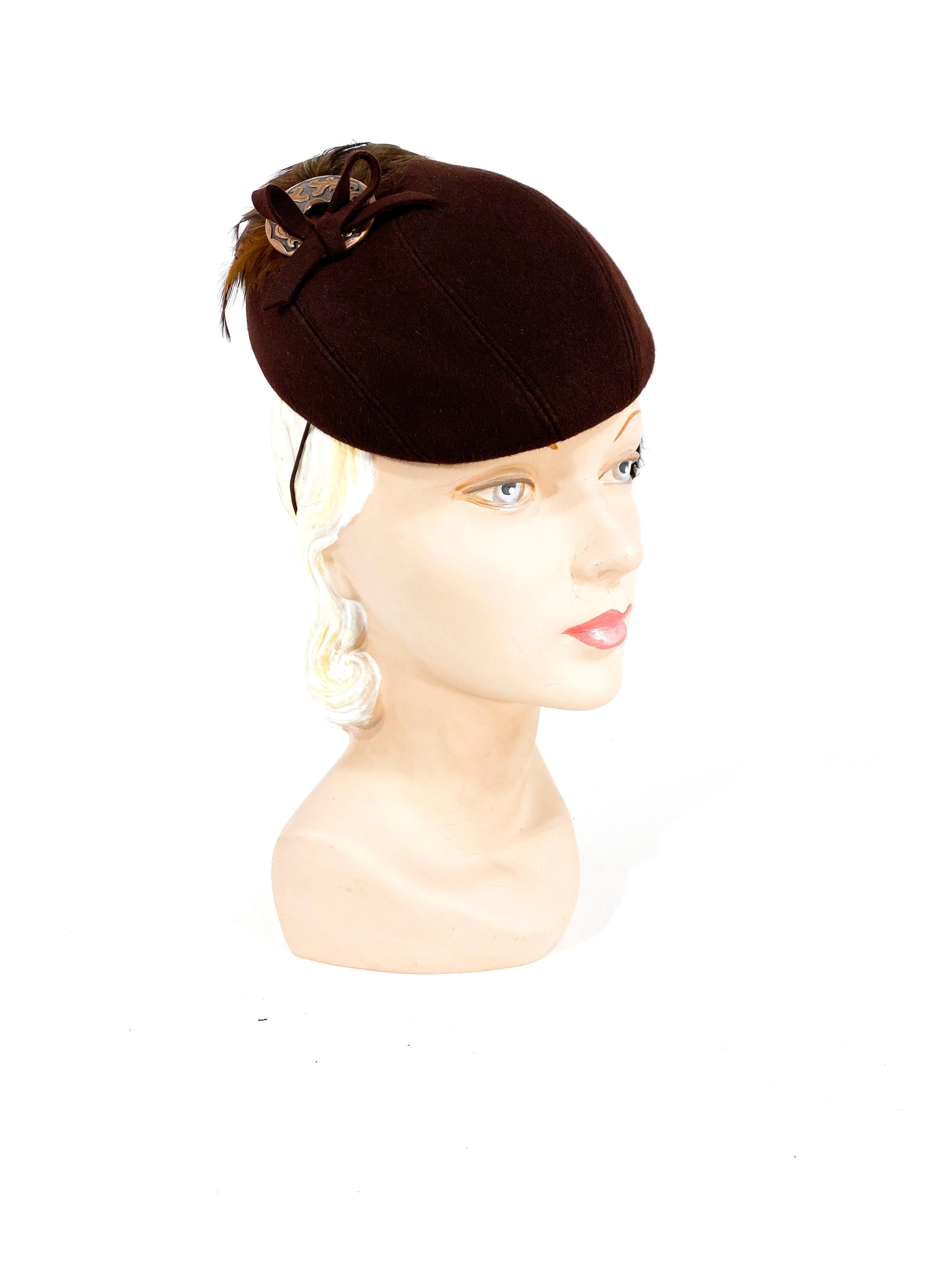 1930s Neiman Marcus brown fur felt hat hand sculpted in to asymmetrical shape. The back is adorned with multi-tones of brown feathers to create a large swoop in the back going from one side of the hat to the other ear. Finished with a decorated