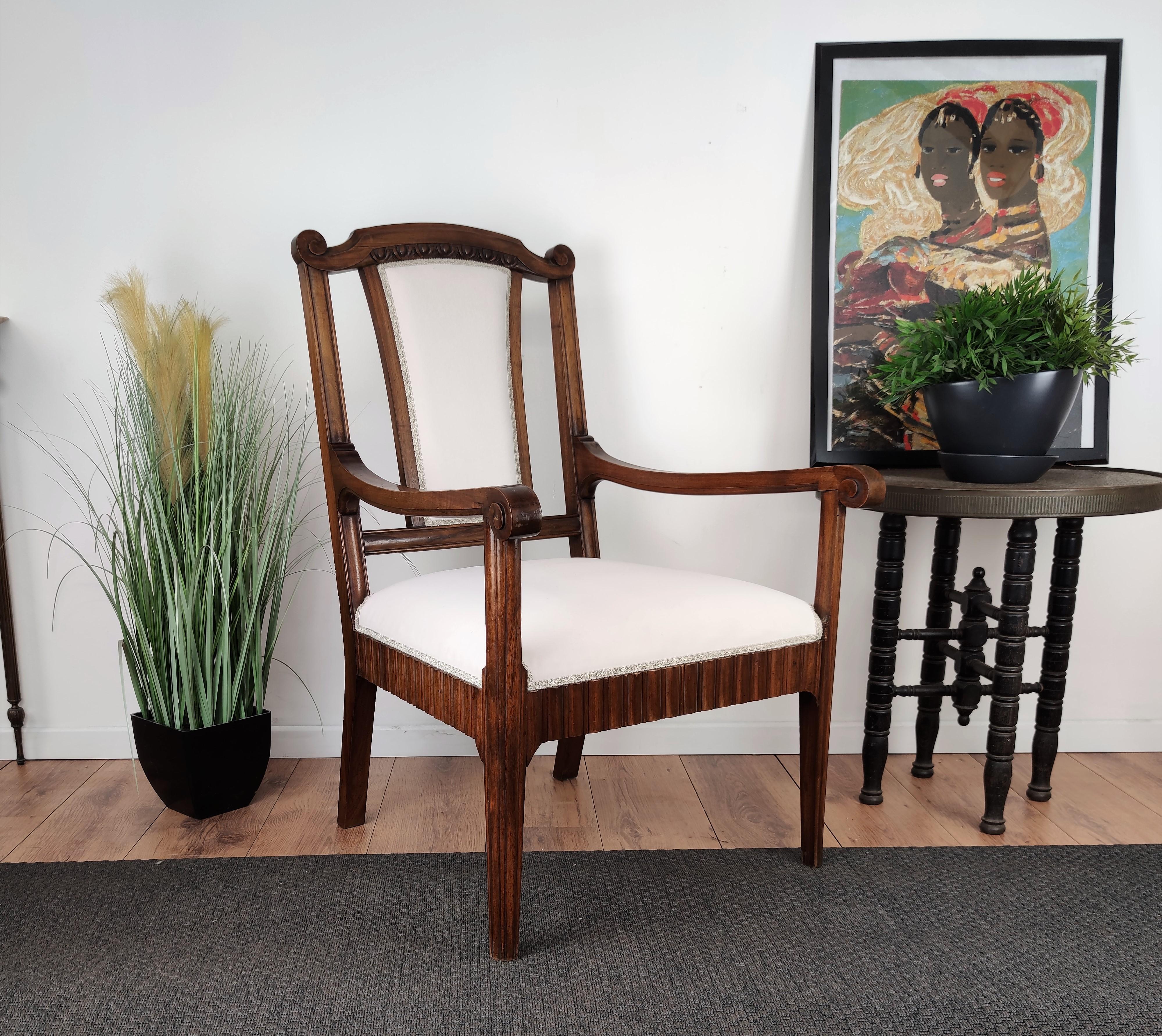 Magnifique fauteuil italien en bois de noyer sculpté, en bon état et entièrement recouvert de tissu blanc. La forme est très élégante et la couleur du bois met en valeur les décors détaillés des pieds, des côtés et du dossier.
 