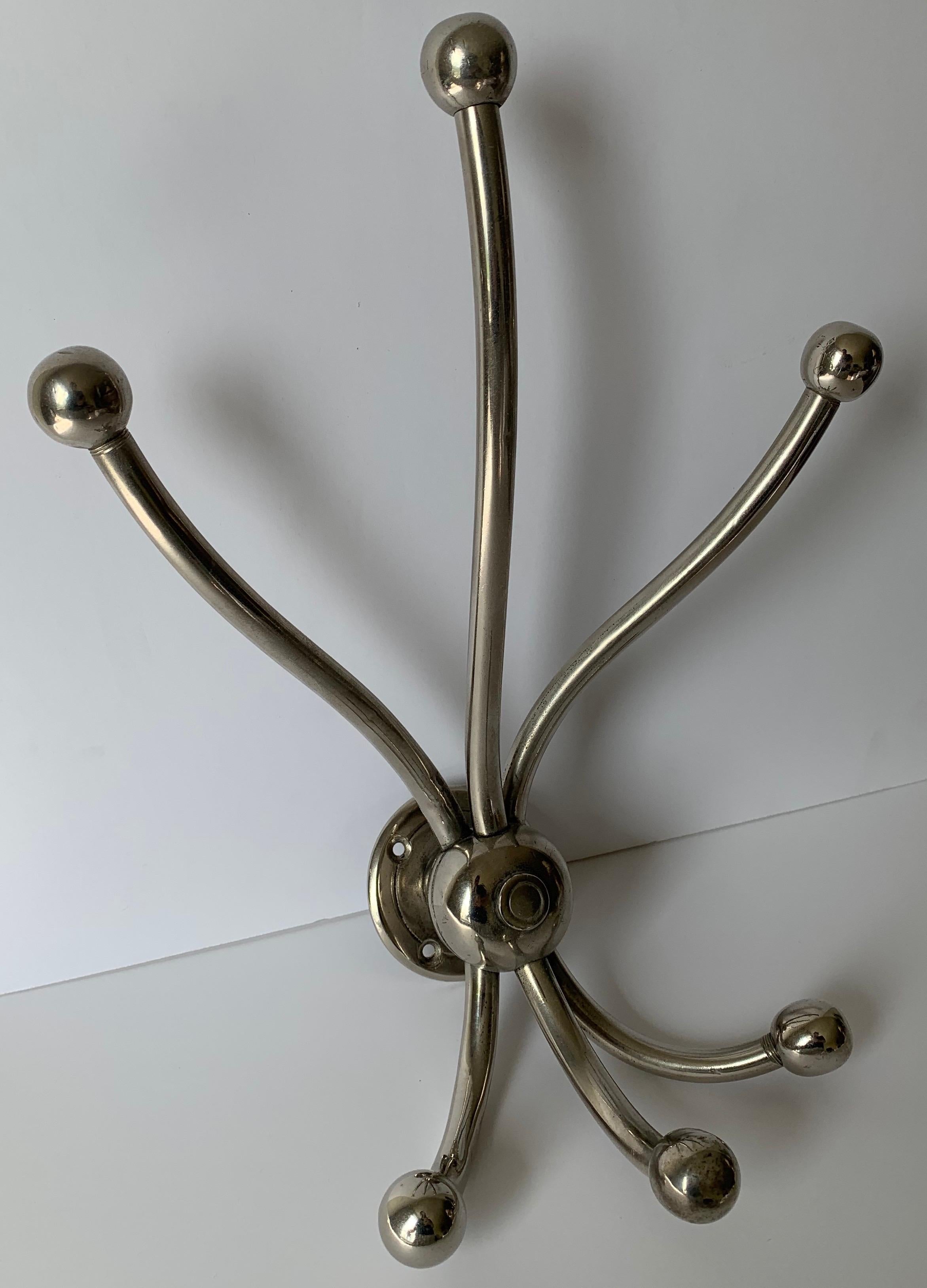 1930s nickel three-arm coat or hat rack. Each arm has two hooks (6 hooks total). Mounting hardware is not included.