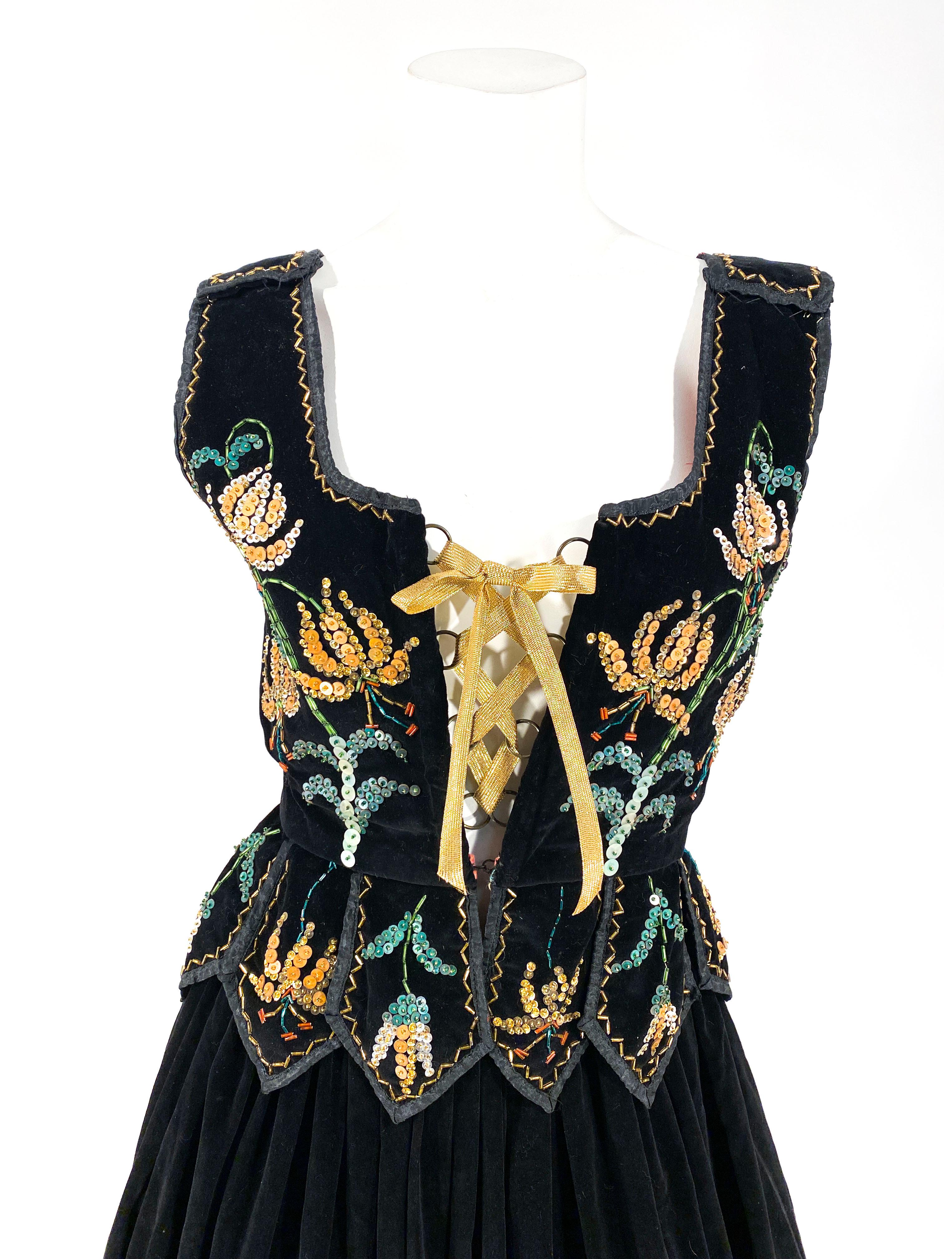 1930s Norther European peasant handmade costume with sequin and glass beading configured into an intricate floral pattern. The fitted tunic laces up with a gold lamé drawstring, decorative tapers that end into a point. The velvet skirt is very full