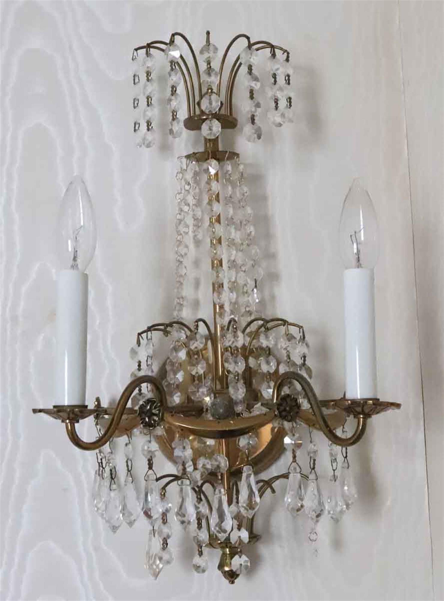 1930s two arm crystal sconces with a brass frame. From the NYC Waldorf Astoria Hotel. Made in Sweden. A Waldorf Astoria authenticity card included with your purchase. Small quantity available at time of posting. Priced each. This can be seen at our