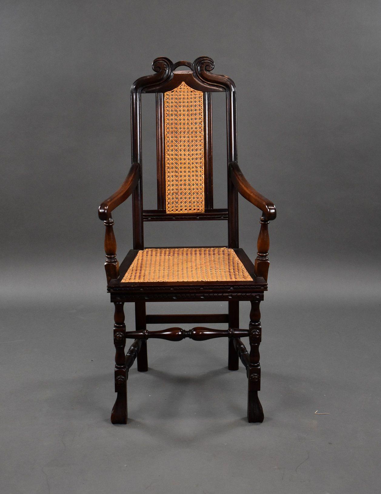 Eichenholzsessel aus den 1930er Jahren mit Sitz und Rückenlehne aus Rohrgeflecht und dekorativer Platte, die von einer Bahre getragen wird.