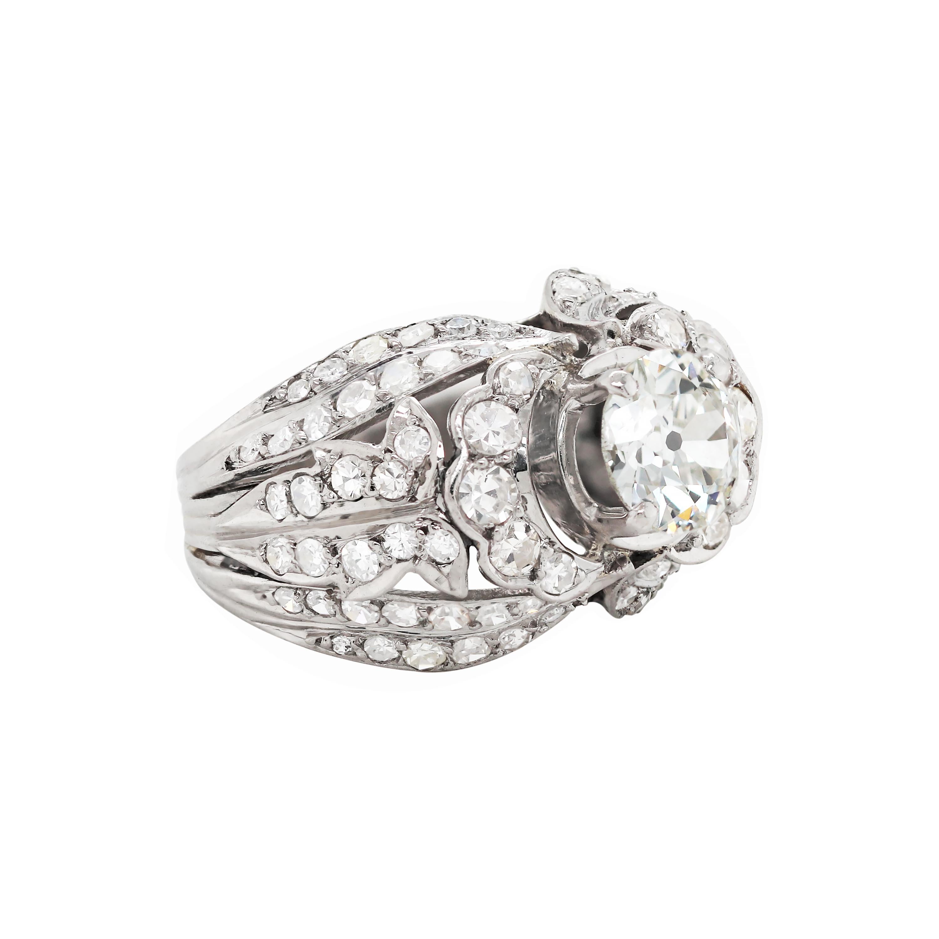 This exceptional handmade dome dress ring features a beautiful old cut diamond claw set in the center weighing 1.42ct. The ring is beautifully made with a grain set open work design mounted with 48 eight cut diamonds on either side, weighing a total