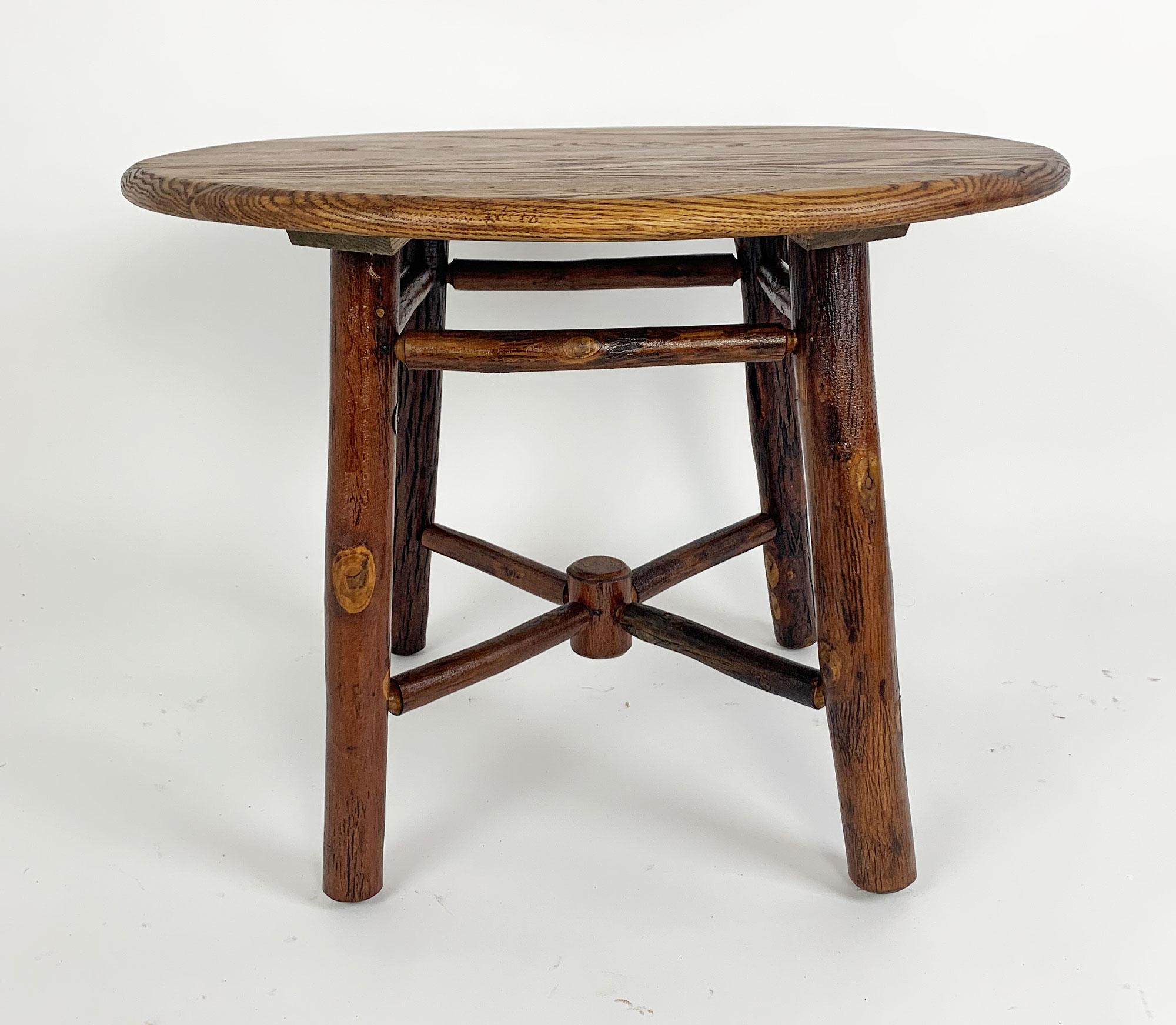 This is a desirable small Old Hickory table with a round oak top and both spoke and straight stretchers on the hickory pole base. It has a Bruce tag with the date 1946.

The top is 24