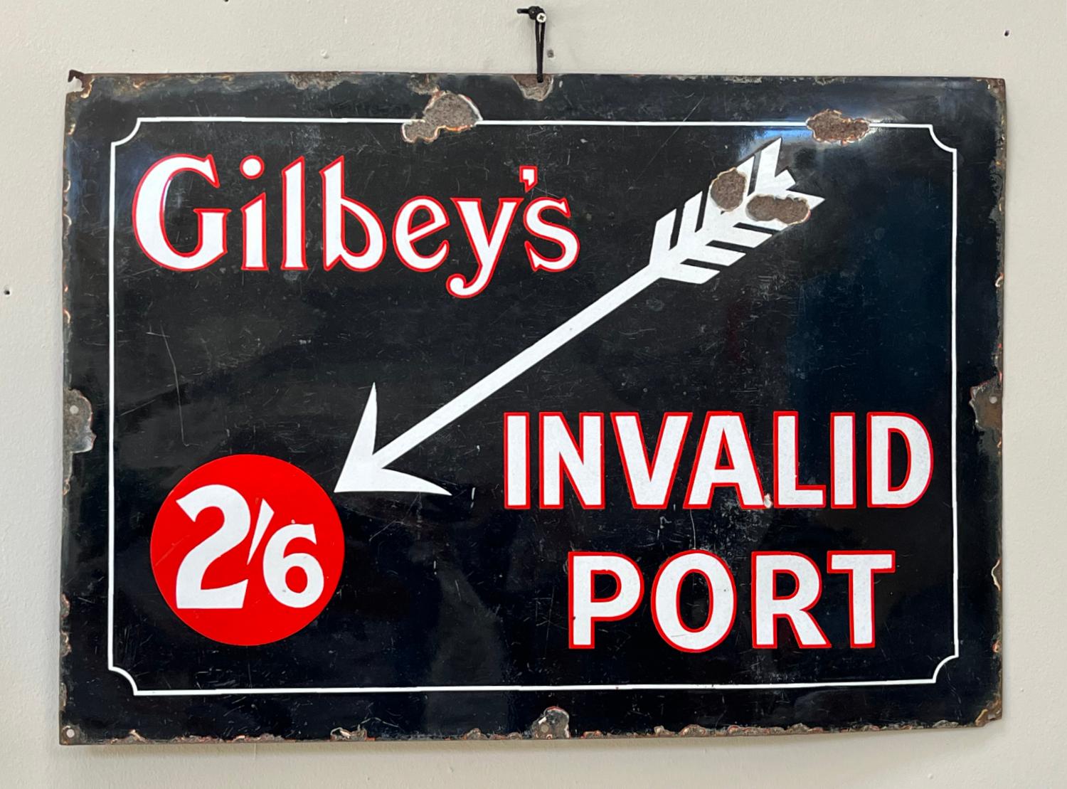 For sale we have a very striking, original 1930s/40s advertising sign in red and white enamel on black-ground for ‘Gilbey’s Invalid Port’. The enamel sign has the most amazing patina and the desired amount of weathering to the edges. 
Gilbey's