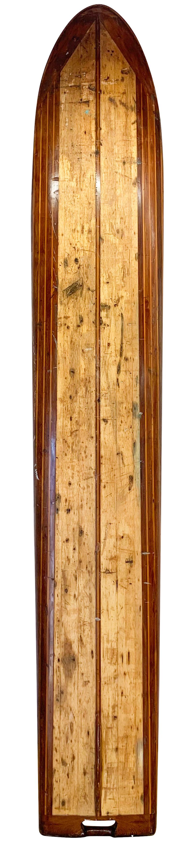 Late-1930s Pacific system Homes wood surfboard. Features an intricate design created with redwood and pine wood. Beautiful embellishments in the form of nose and tail blocks complete with an early style surfboard fin with low profile. This early