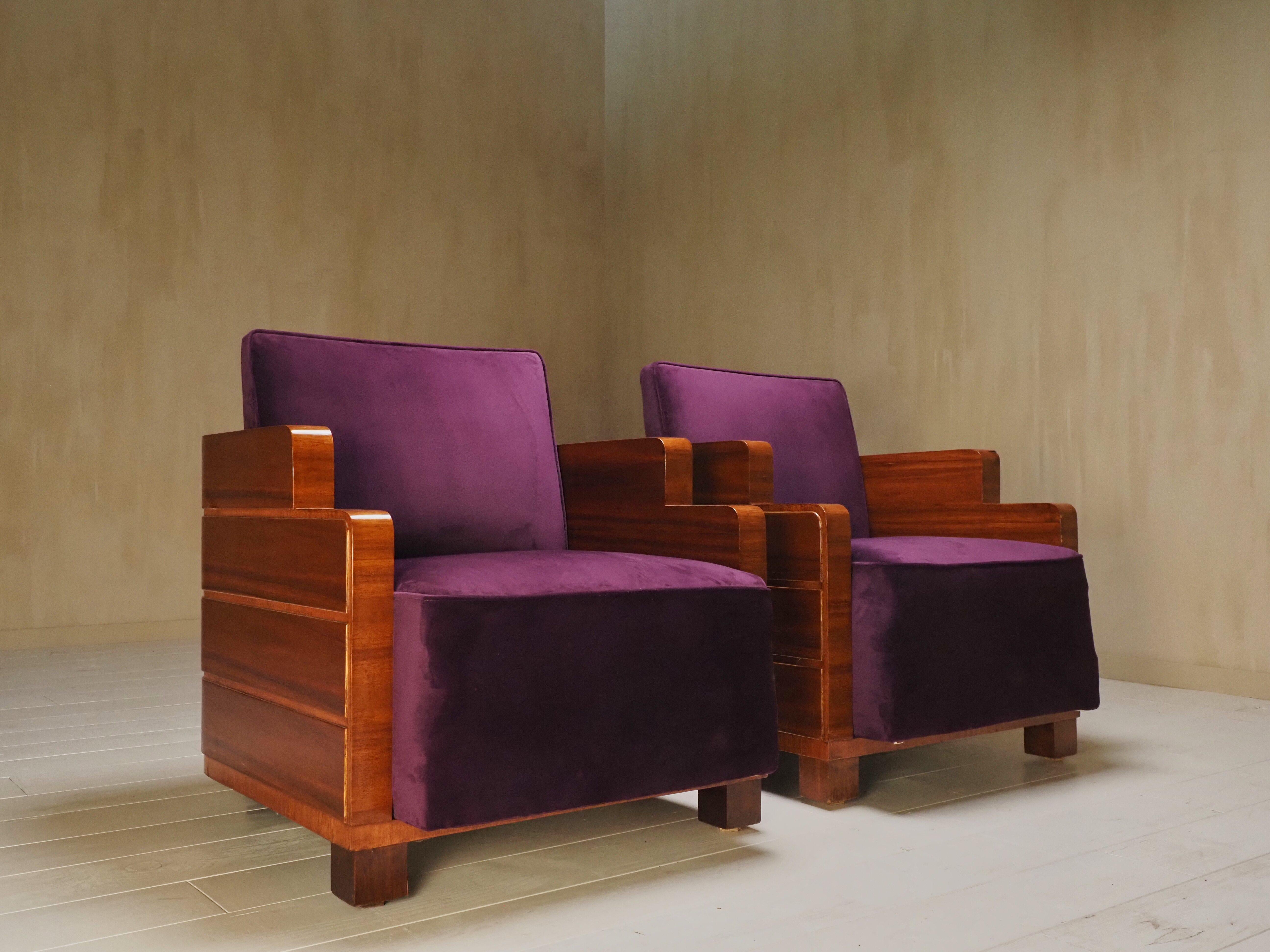 Cette paire de fauteuils saisissante incarne l'élégance audacieuse du mouvement de l'école d'Amsterdam, un élément clé du design Art déco néerlandais des années 1930. Récemment retapissées dans un riche et luxueux tissu violet, ces chaises allient