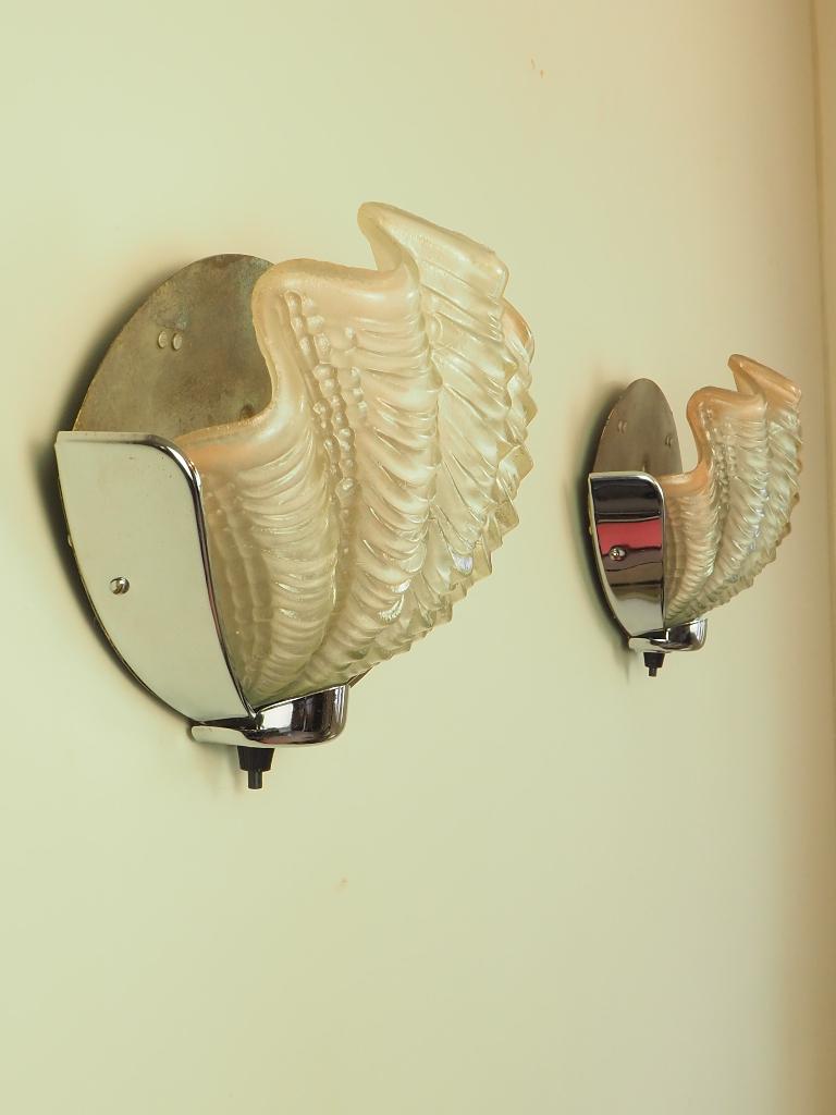 Exquisite pair of Art Deco Clamshell Wall Lights from the 1930s. The chrome frames add a touch of elegance and sophistication, while the textured glass with pink shading creates a beautiful effect that emits a soft, warm glow when