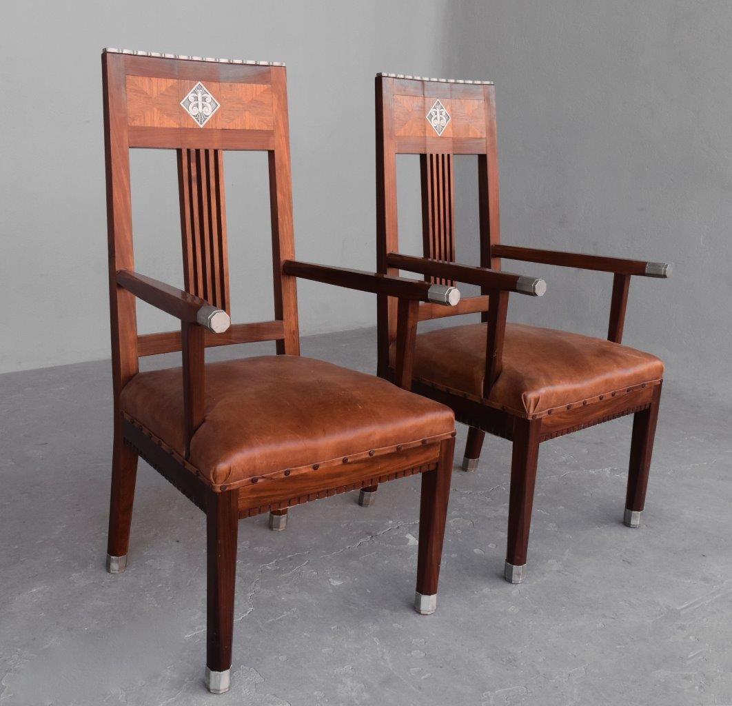 1930s pair of Art Déco rosewood armchair. Seating covered with leather. Decorated with cast iron alloy plates with insects. Work in the style of Dominique from Paris.