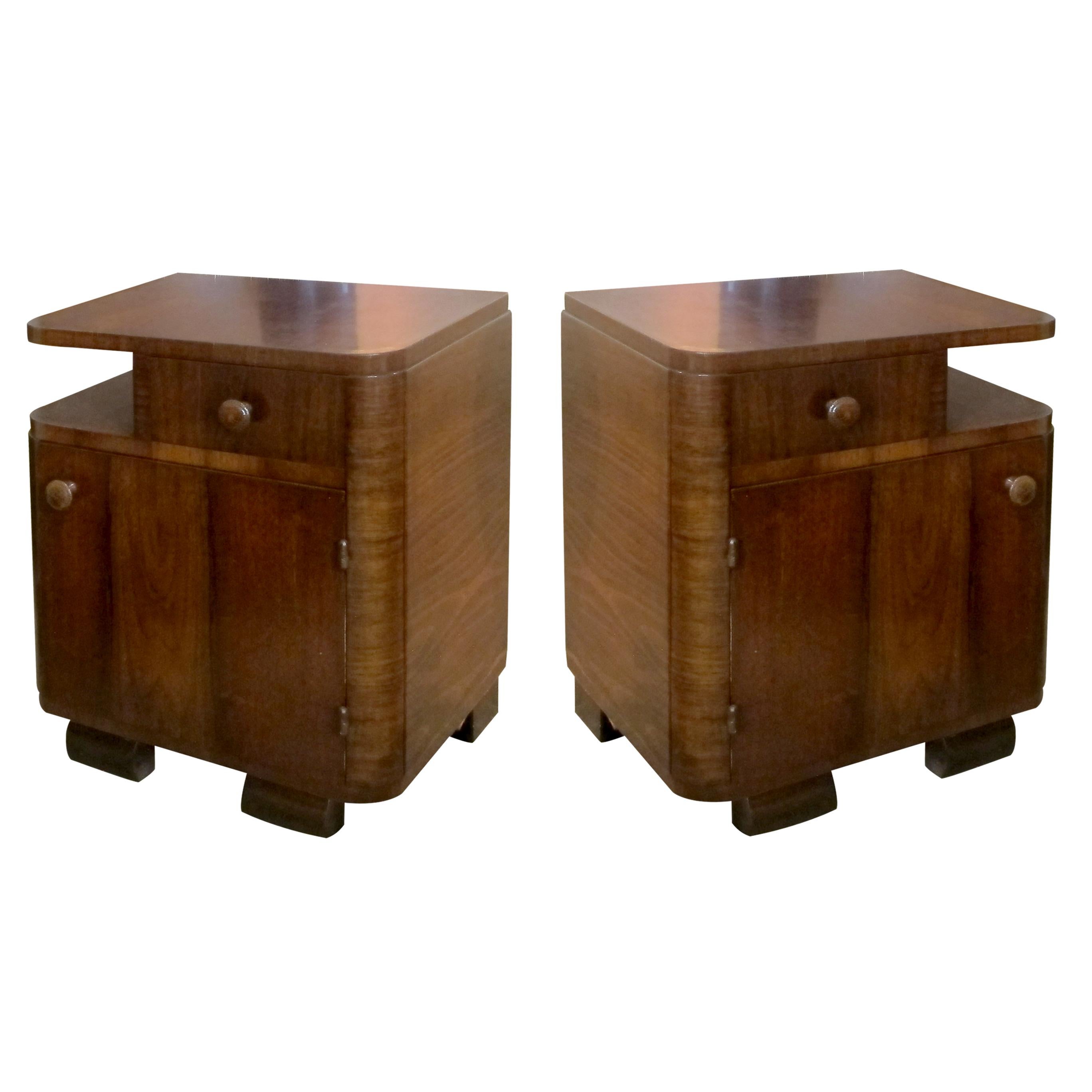Pair of French Art Deco bedside tables/nightstands with walnut veneers in good original condition. The Art Deco influence is evident in the clean lines silhouette and curved edges, they would be a great addition to classic and contemporary
