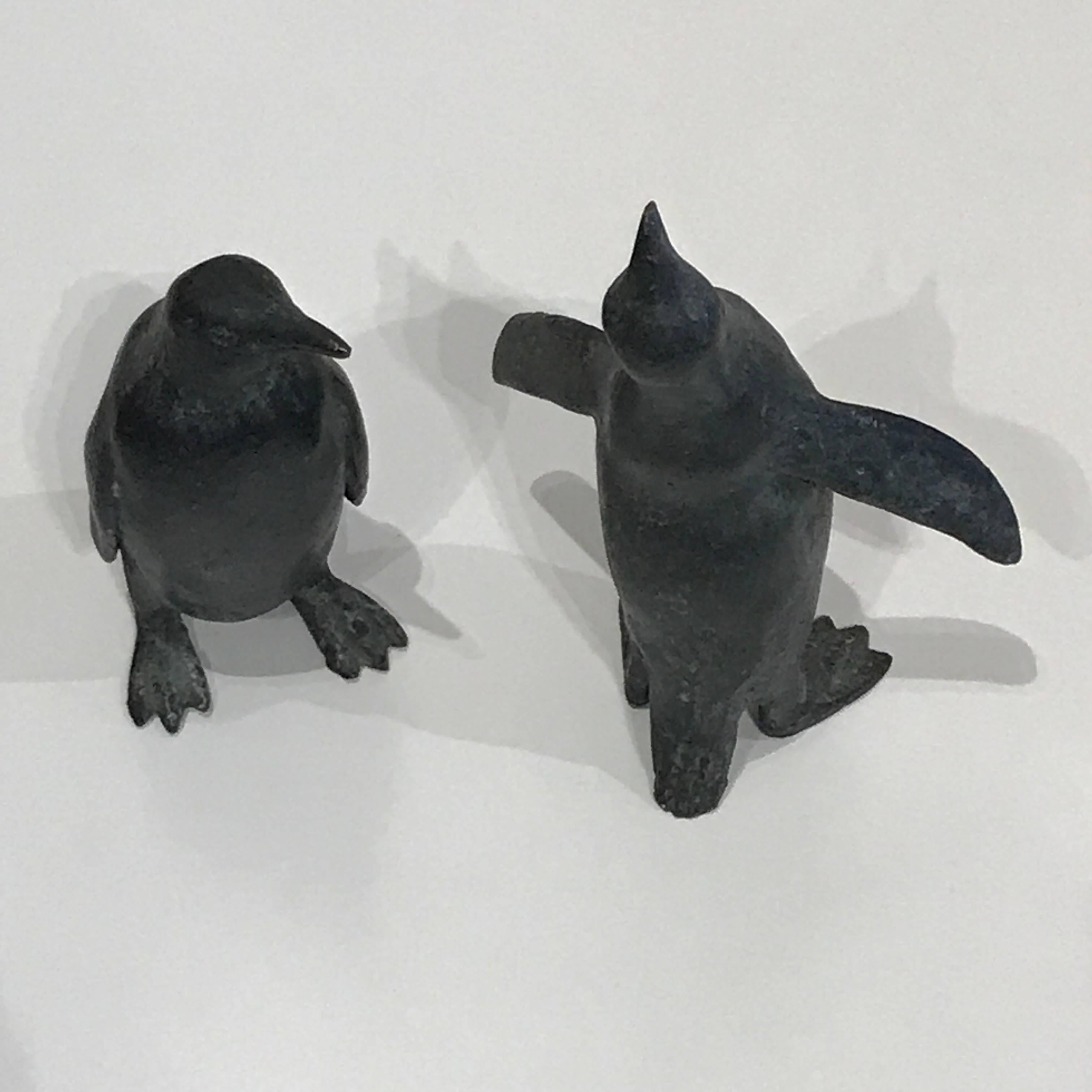 Pair of cast solid bronze expressive penguins, having a very dark patina from age, both are numbered 2/25 at the base of the tail. The sizes are 5.50