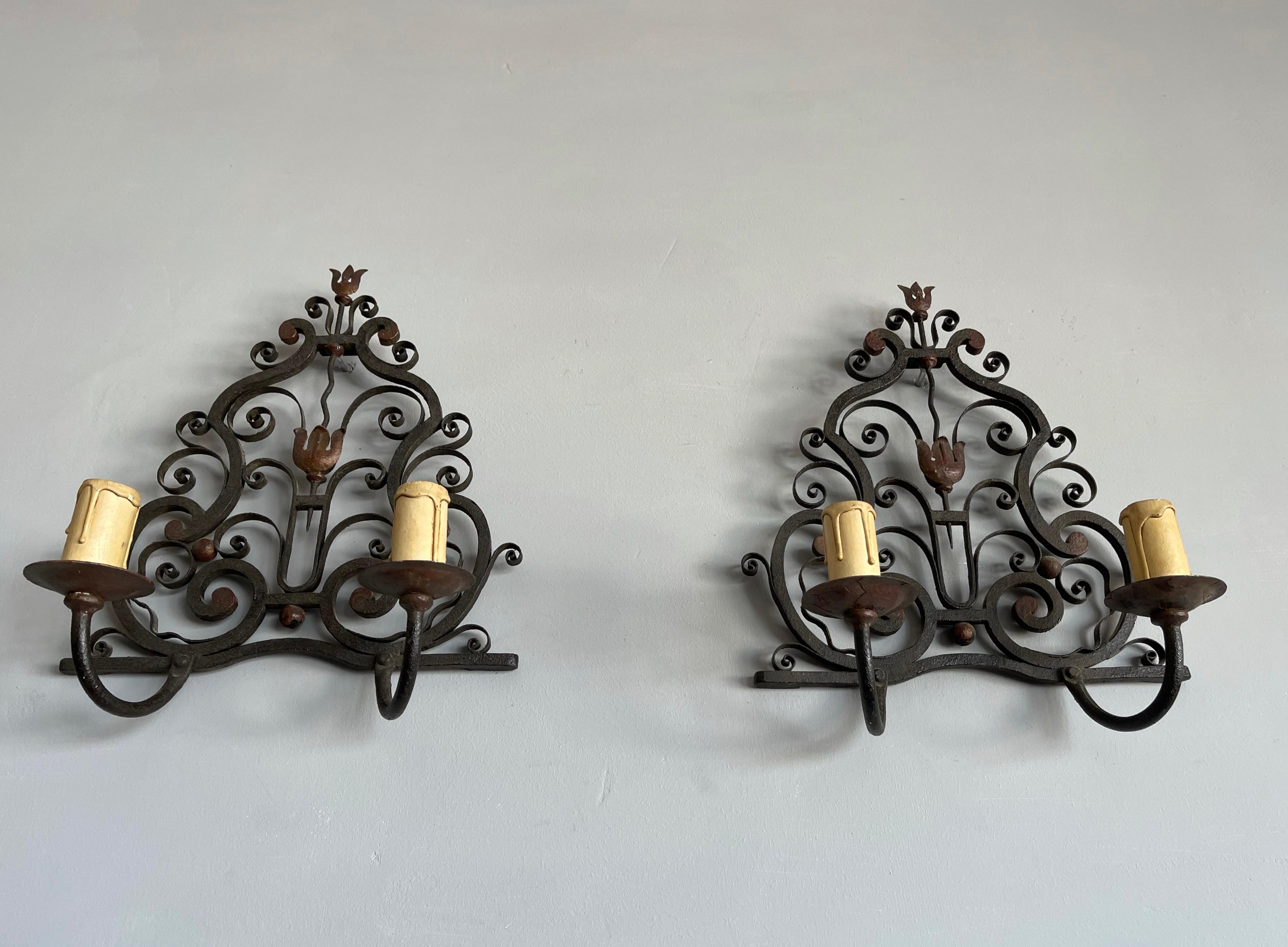 Stylish and perfectly hand-forged iron wall sconces in the style of Gilbert Poillerat.

This rare and all handcrafted pair of wall sconces is in very good condition. The wonderful and perfectly symmetrical flowing design of these growing flower