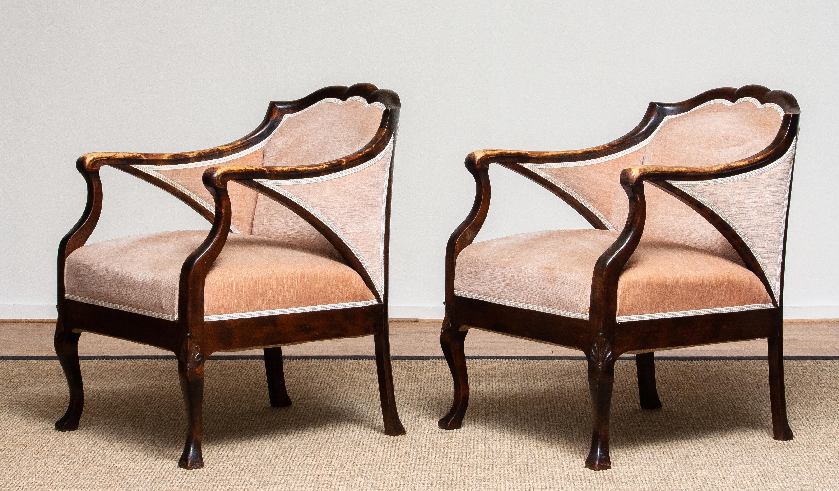 Beautiful set of two Art Nouveau easy Stockholm chairs in beech upholstered with Salmon color velvet after Fritz Hennings from the 1930's.
What makes the chairs particularly beautiful is the discoloration on the armrests over the years.
Both