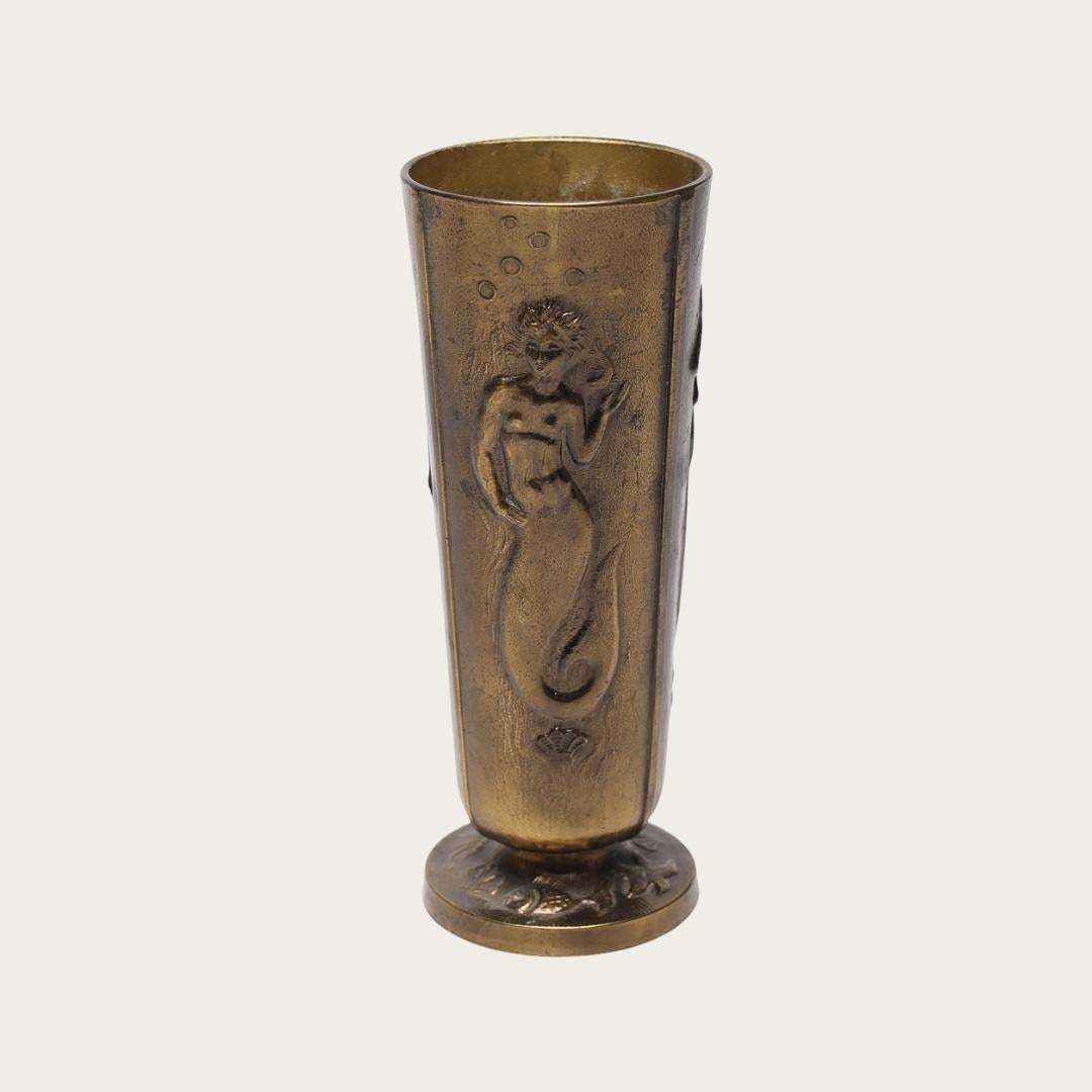 With a group of three different mermaid reliefs sculpted into a vase. With flared base detail. Maker unknown. Marked “Made in Sweden” on underside.