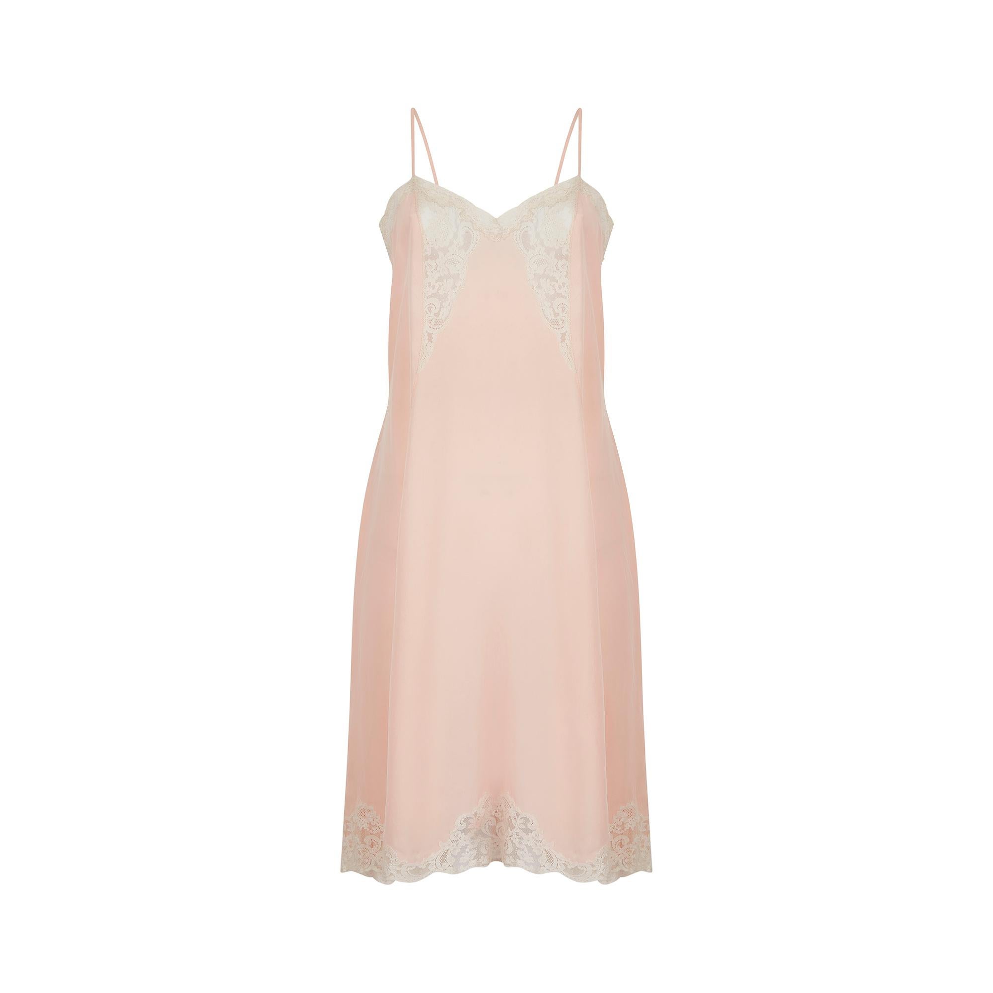 This peachy pink silk late 1930s slip dress has the most beautiful lace insert detail to the bust and on the hem. It is cut in a very classic style, loose and flowing, with a slightly wider shape at the hip for a feminine silhouette. The bust is