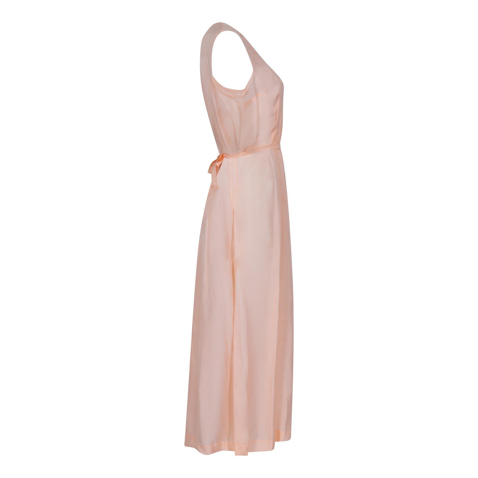 Early 1930s peach embroidered floral slip in incredible antique condition. This piece is made from a man made silk blend in a really beautiful soft peach colour. There are some pleasing design details on this dress including the embroidered neckline