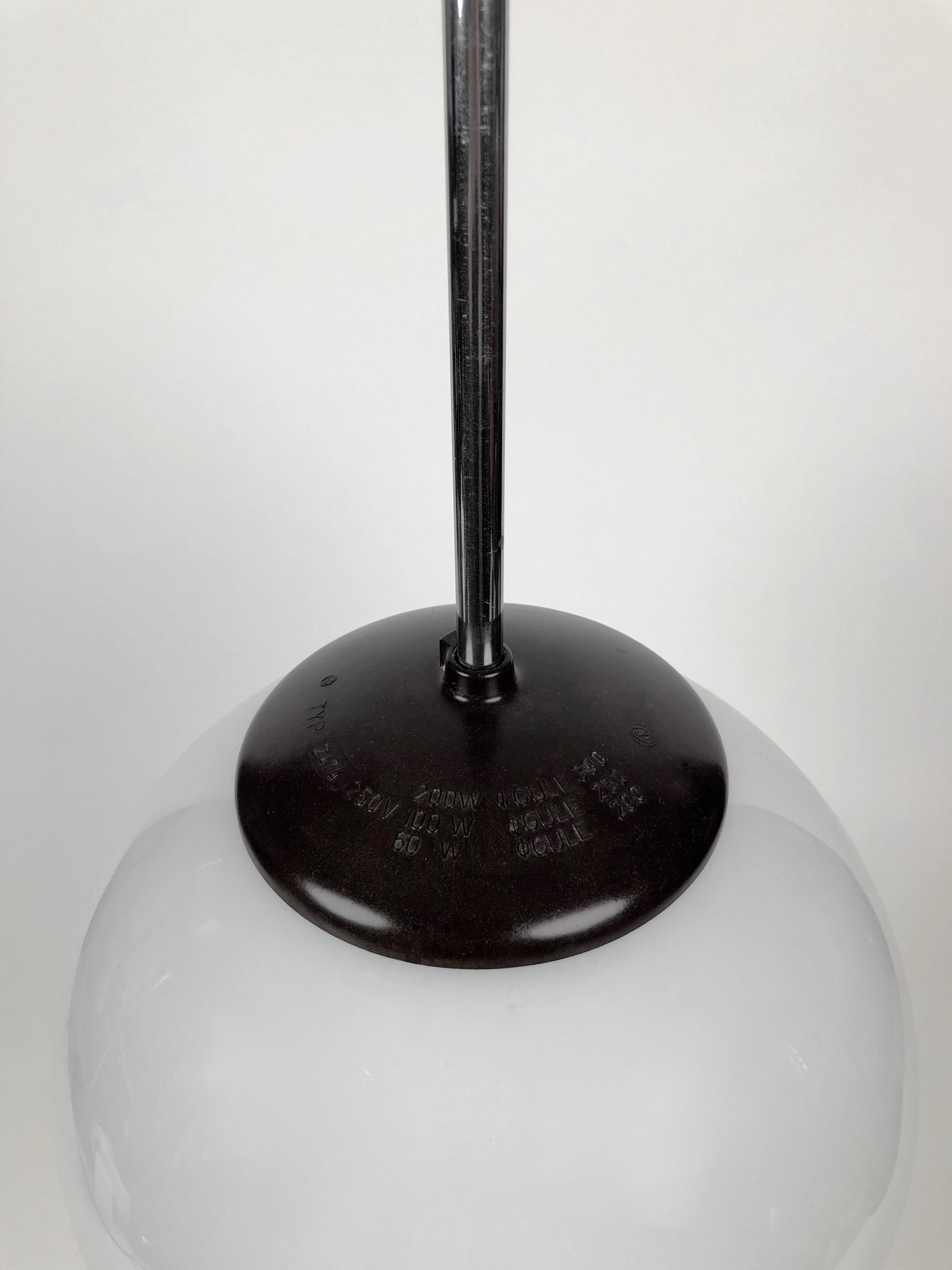 Lampe à suspension classique des années 1930 avec globe rond en verre opalin. Le design a des influences Bauhaus. La Bakélite est en très bon état.