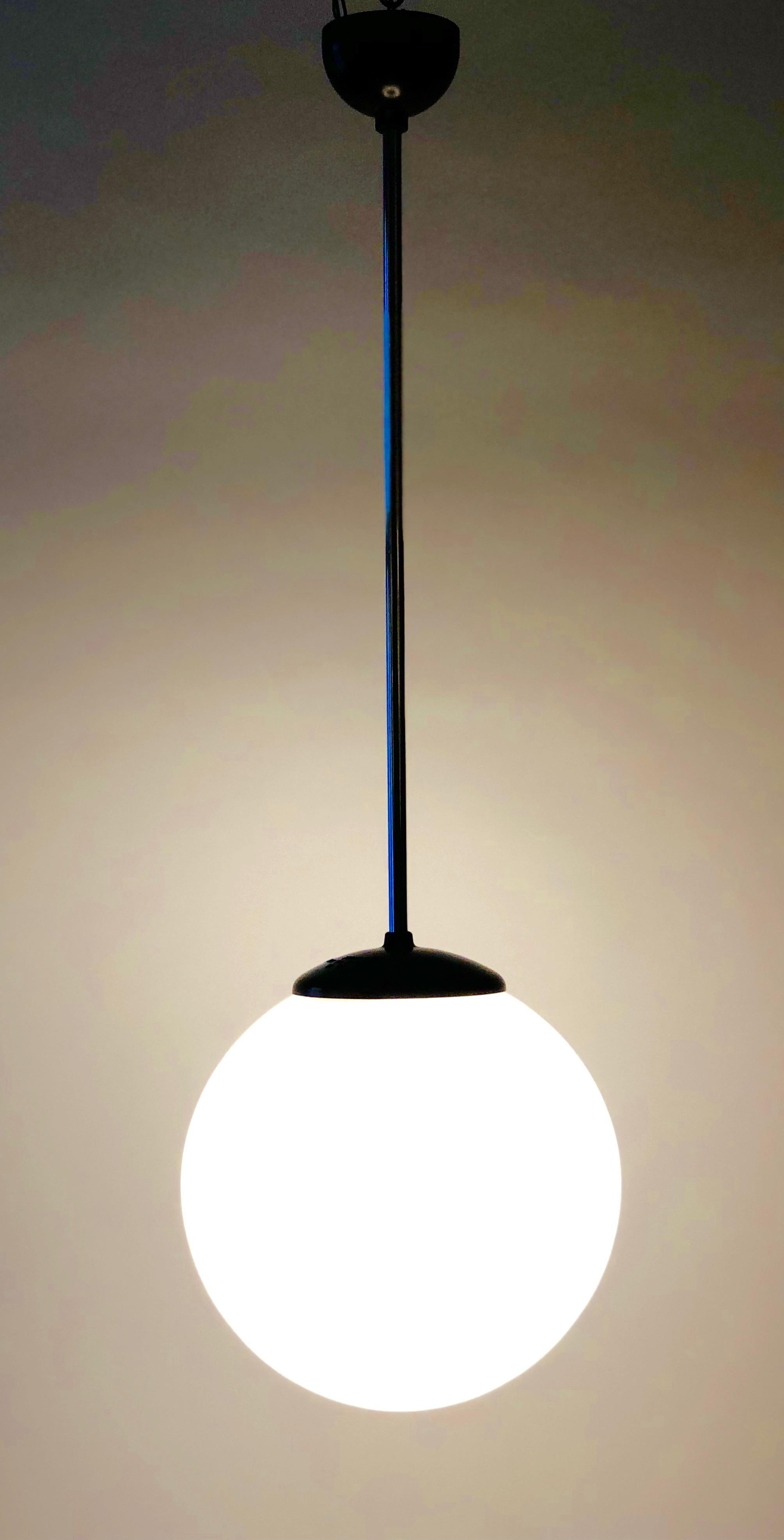 Autre Lampe à suspension des années 1930 avec abat-jour rond en verre opalin et éléments en bakélite en vente