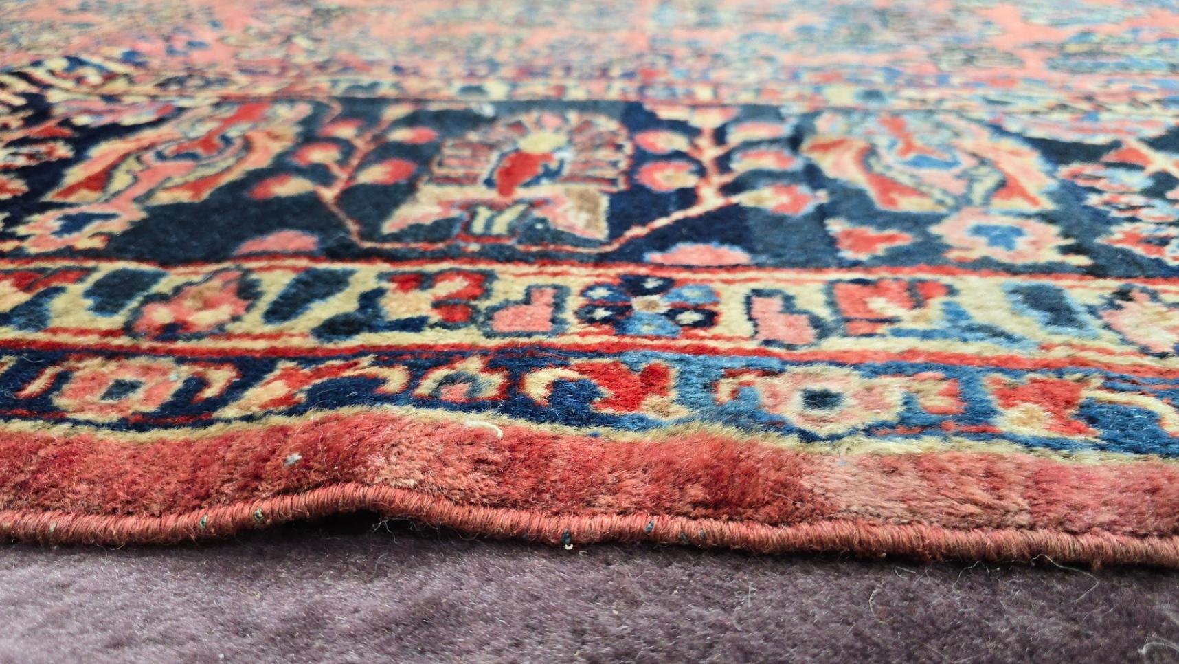 Aggiungi un tocco di raffinata eleganza al tuo spazio con questo antico tappeto persiano Sarouk, un raro capolavoro persiano caratterizzato da un ricco campo blu e da intricati motivi floreali. Questo tappeto annodato a mano, che misura 9,1x14,4