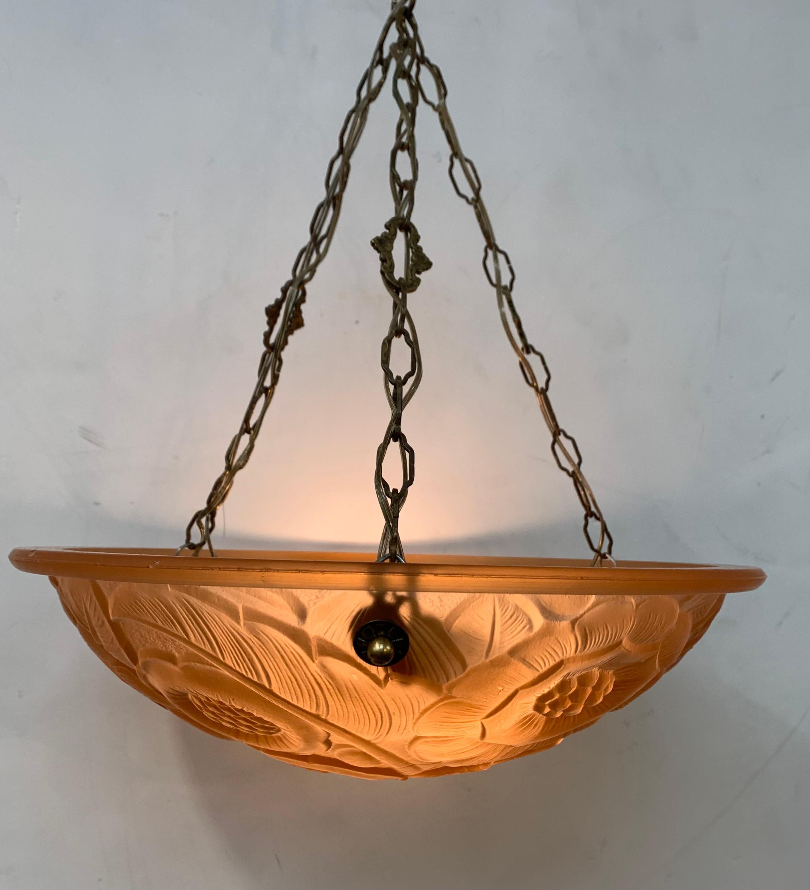 1930s Petitot salmon colored French glass bowl chandelier. Molded salmon colored glass shade is decorated in a floral pattern. Held by three (3) period brass chains and matching canopy. Fixture has been rewired to American standards with three (3)