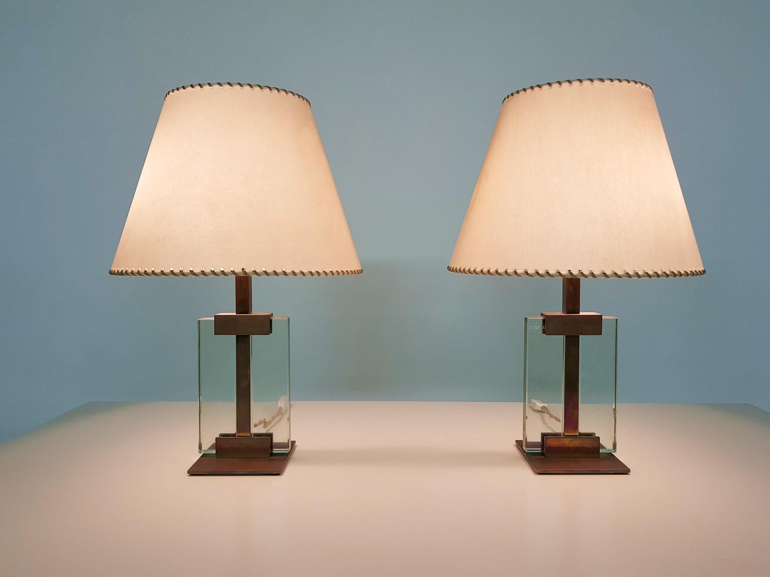 Amazing, hard to find pair of bronze and glass table lights by the famous high end lighting manufacturer Fontana Arte, made and designed in the 1930s. 

A same pair of floor lights is documented on page 202 of the lighting bible 
