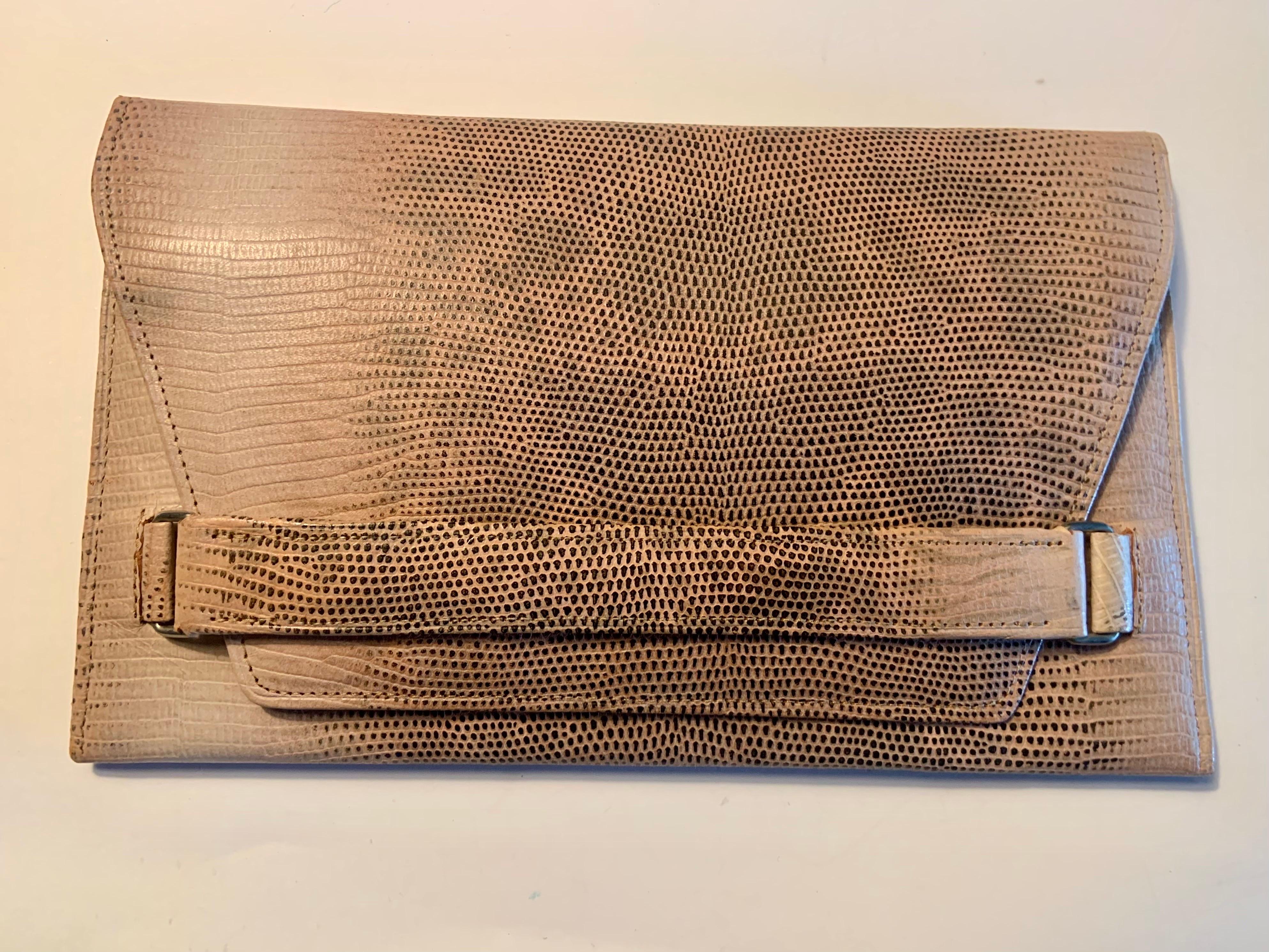 Questa pochette in lucertola rosa pallido degli anni '30 è in condizioni così immacolate che sembra sia stata realizzata ieri.  Il fronte  Il lembo si infila in una fascia di lucertola ancorata da due anelli di metallo. Aprendolo, troverai uno